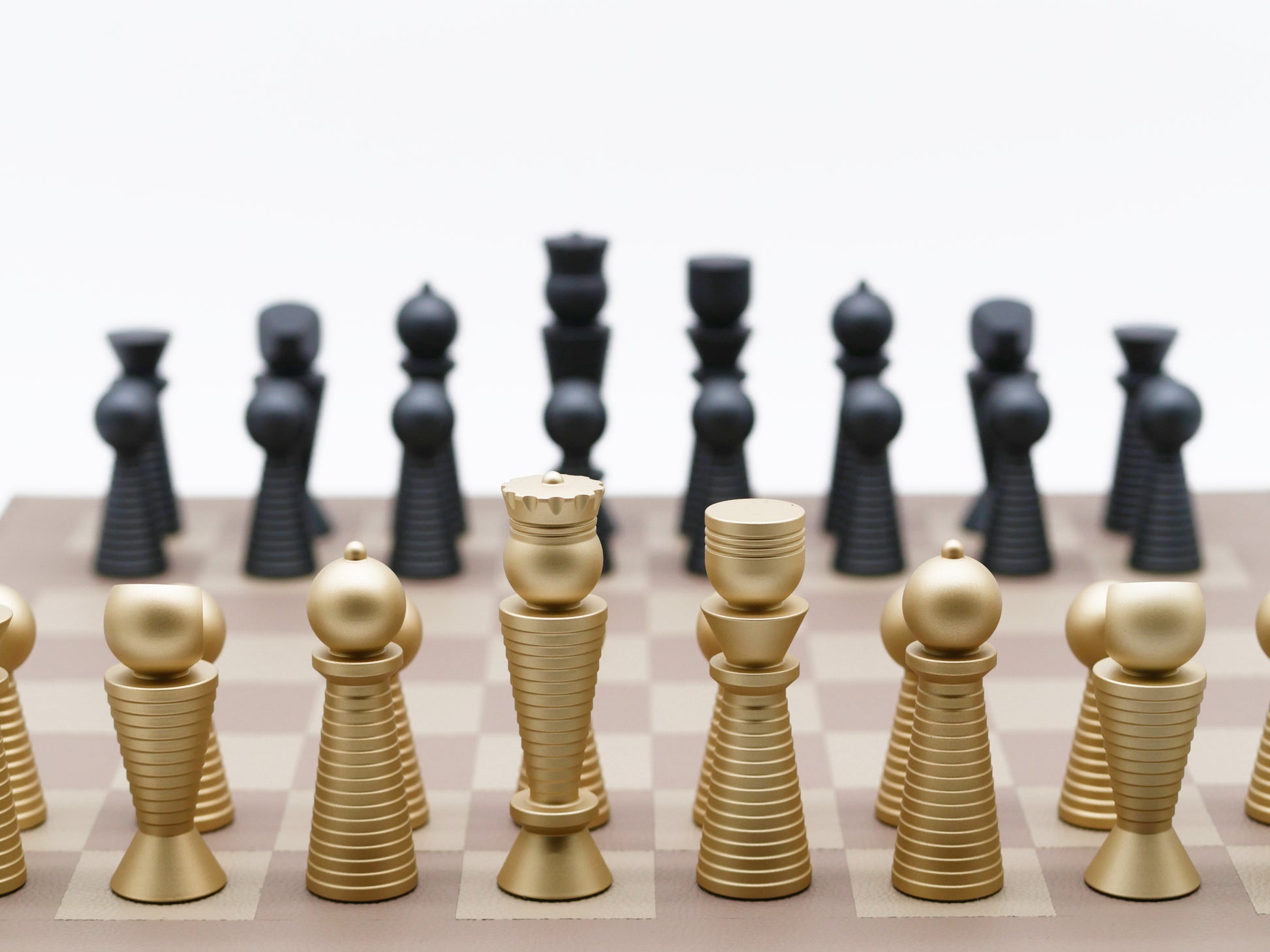 Close up of a two in one chess set in a wooden storage case with black and gold pieces arranged in compartments