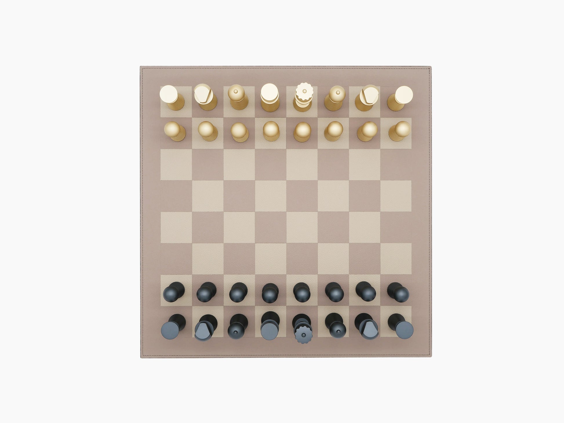 Overhead view of walnut wood and leather bordered two tone chess board with gold pieces on the top and dark pieces on the bottom