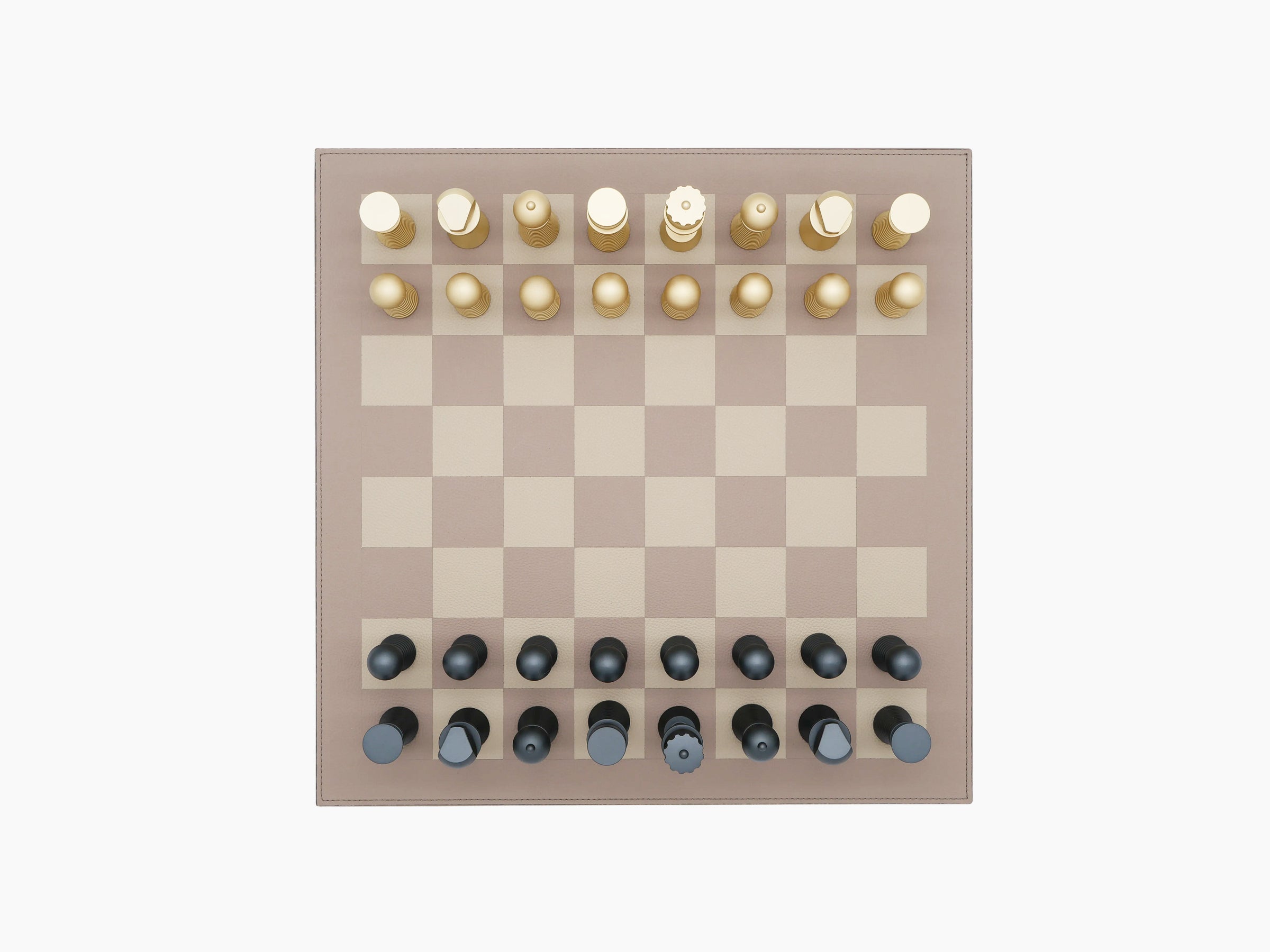 Overhead view of walnut wood and leather bordered two tone chess board with gold pieces on the top and dark pieces on the bottom