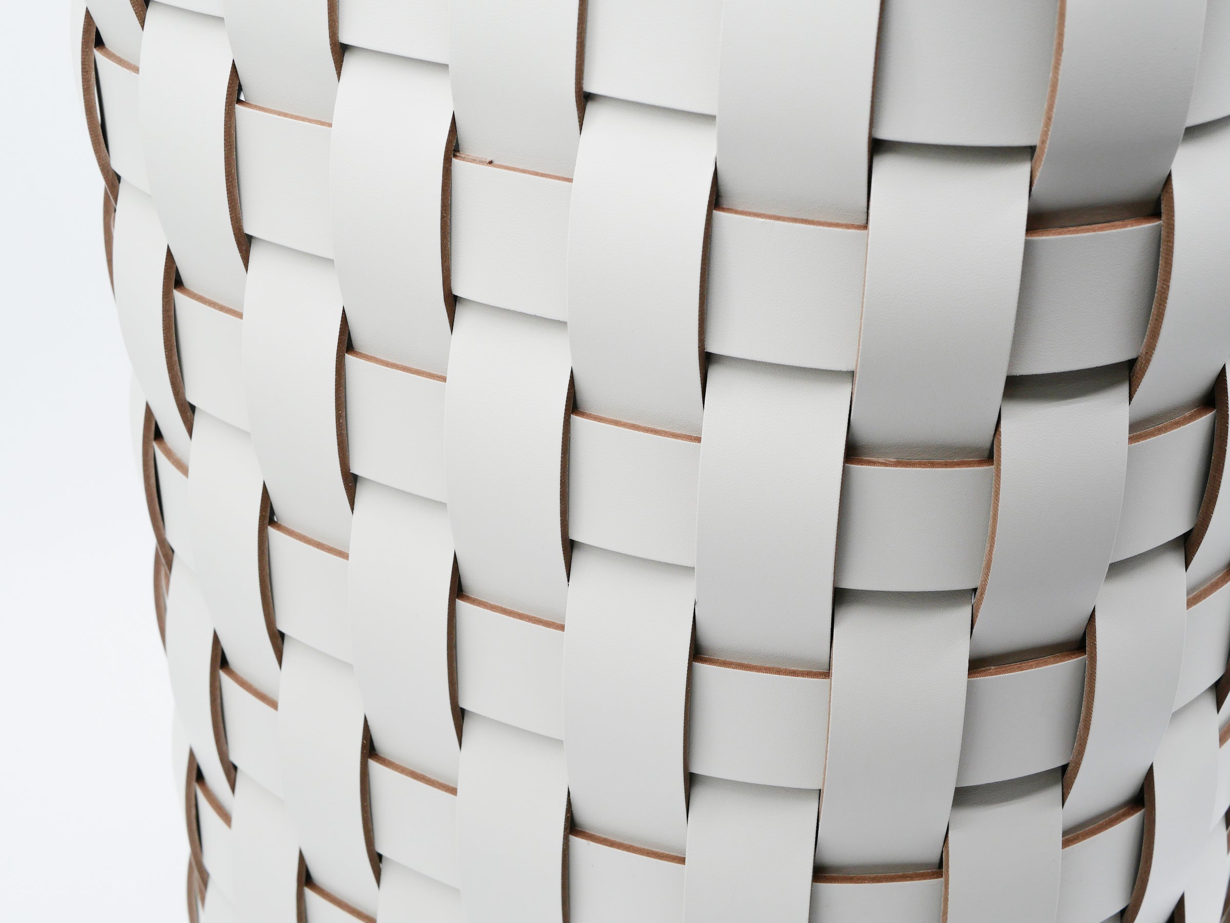 Detail of Demetra Basket showing handwoven leather strips forming a textured weave