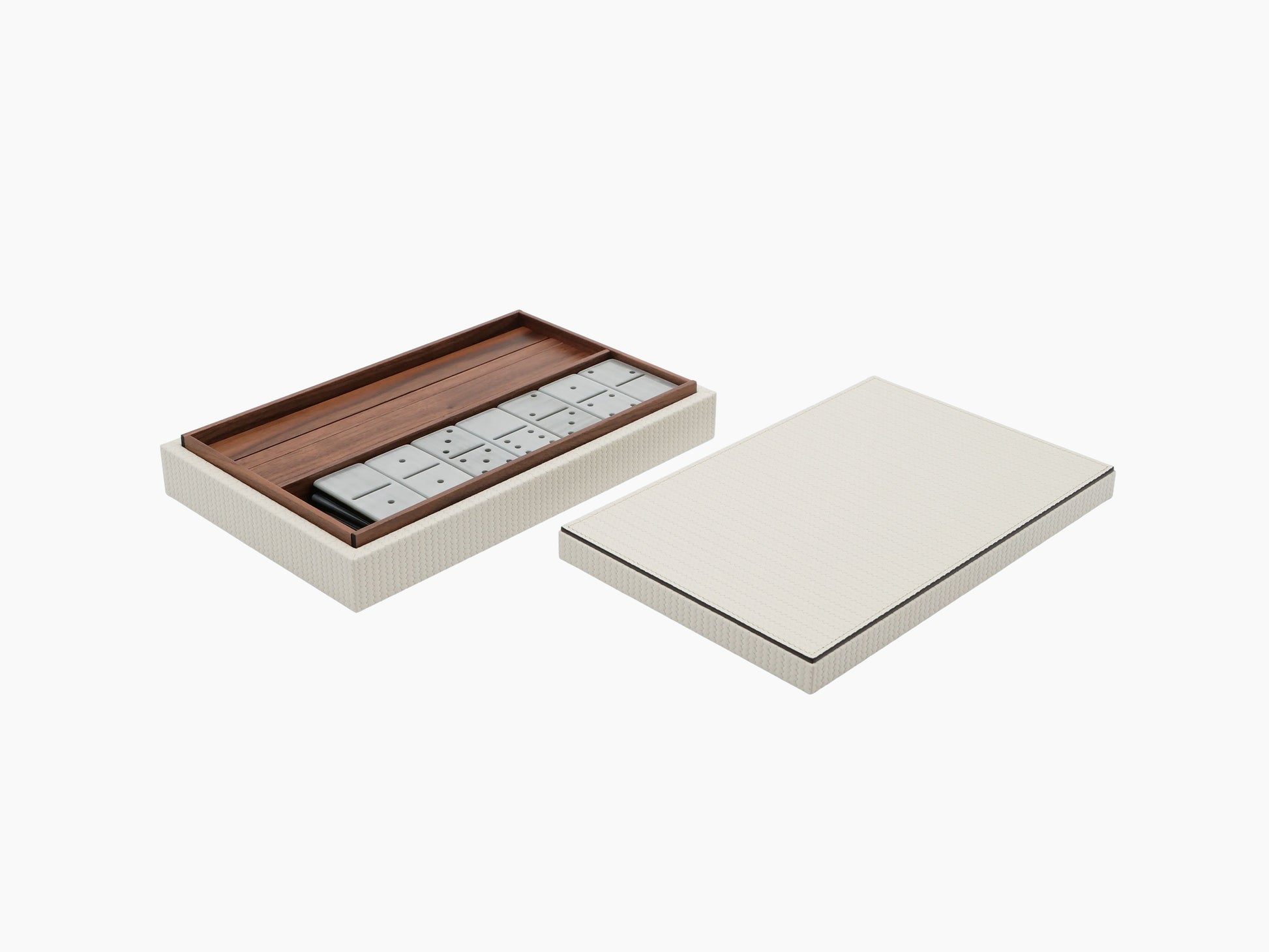 Opened dominoes box reveals wooden tray and domino tiles beside the cream textured lid