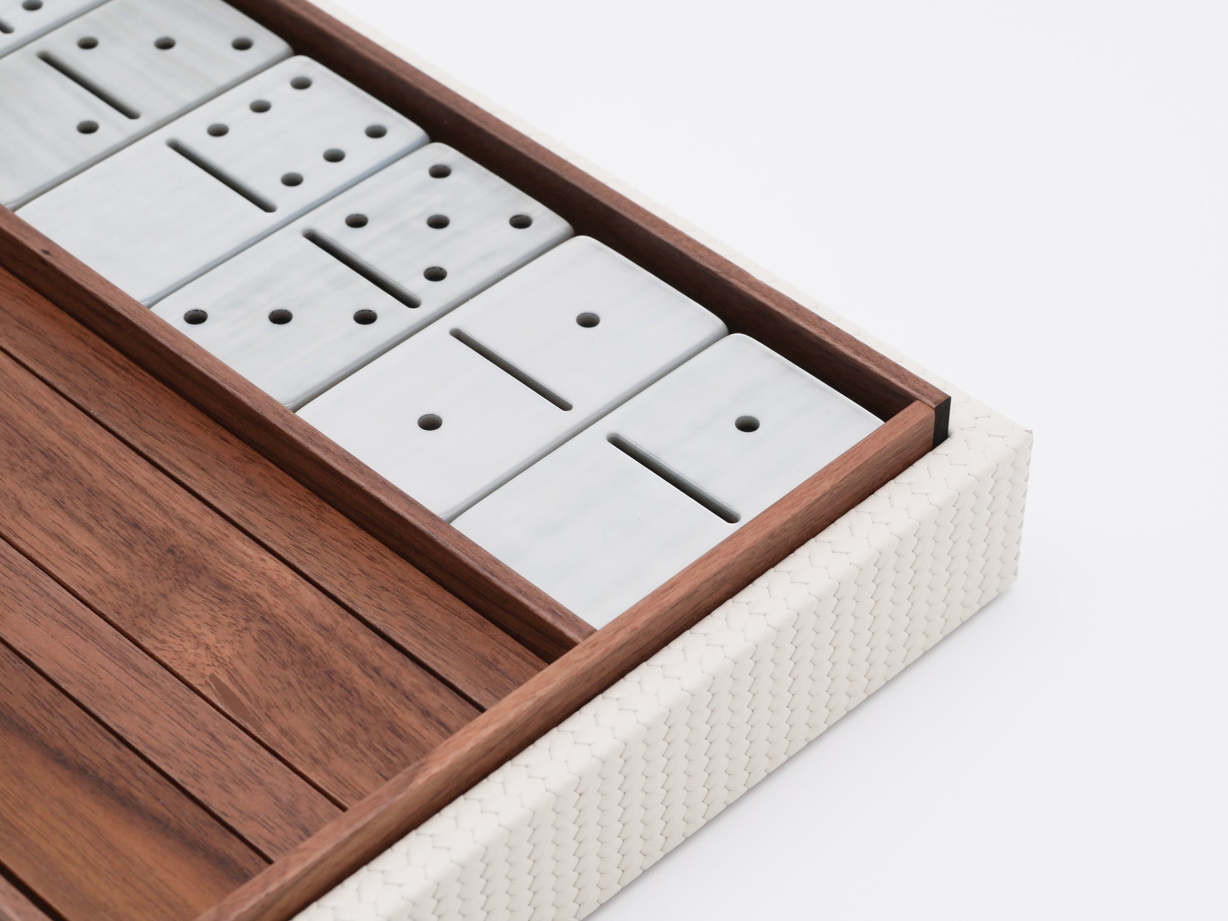 Timeless dominoes tiles arranged in a leather covered wooden box with walnut trim.