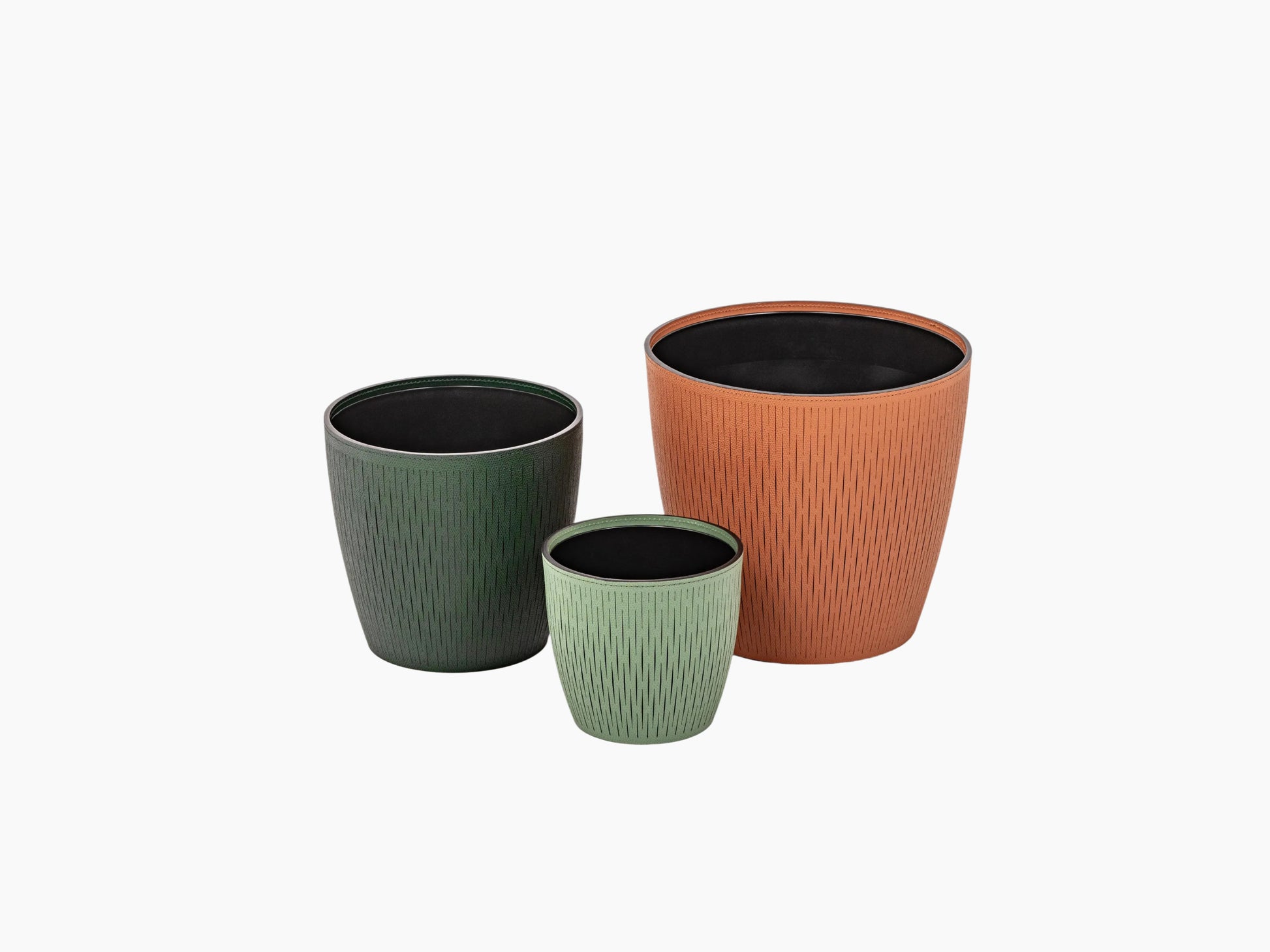 Three Silvy flower pots in dark green sage green and terracotta with a textured vertical pattern and black interiors