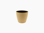 Medium Silvy Flower Pot in tan with a black interior and vertical pattern.