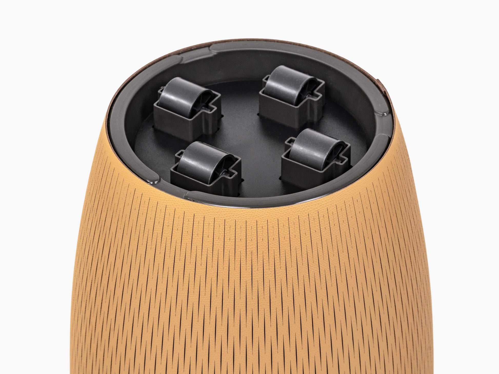 Close-up of the top rim of a Silvy pot showing tan textured exterior, black interior, and wheel mounts.