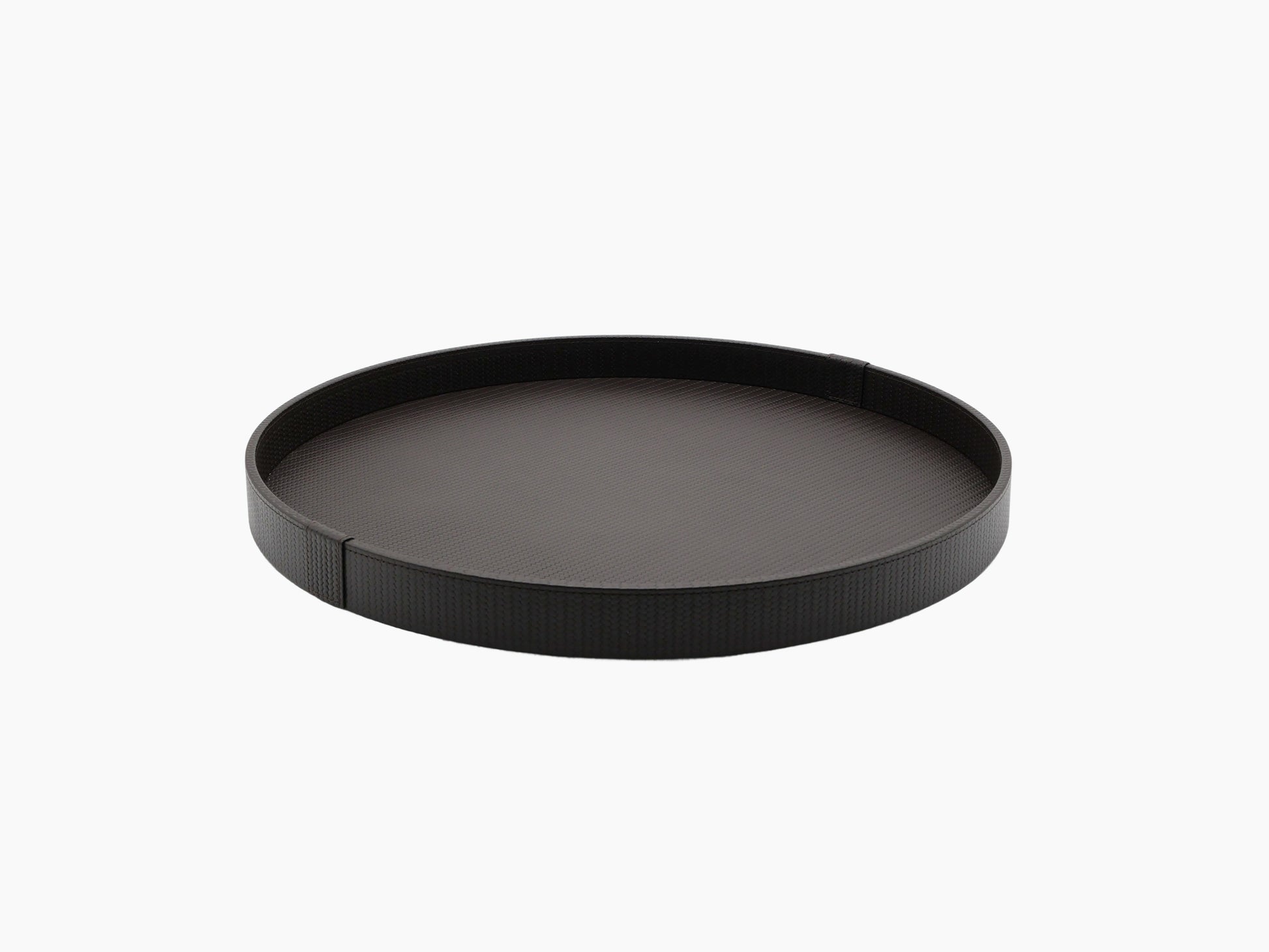 Dark round leather tray with crocodile texture seen from an oblique angle.