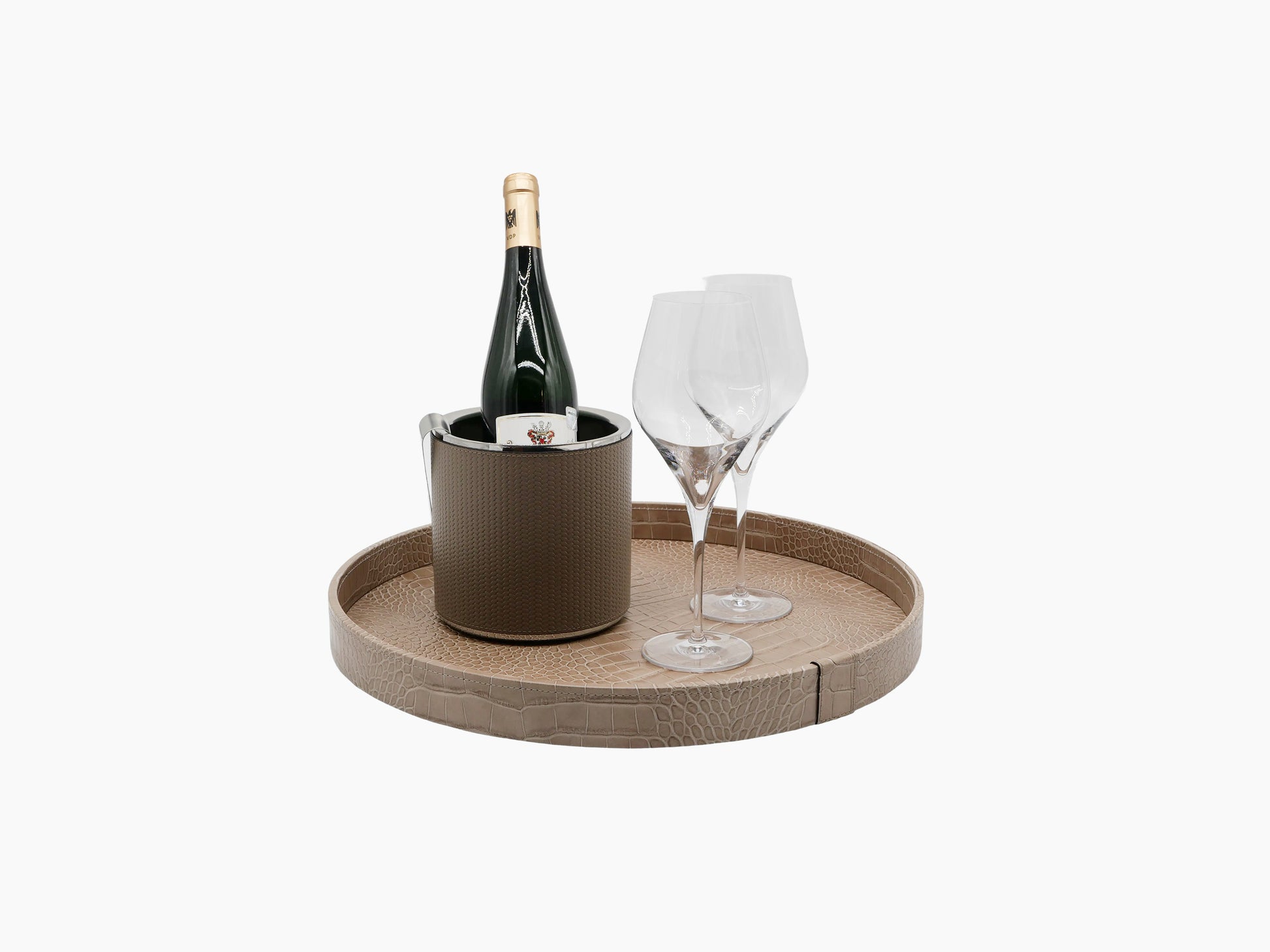 Gea medium round tray in beige textured leather holding a champagne bottle and two stemmed glasses