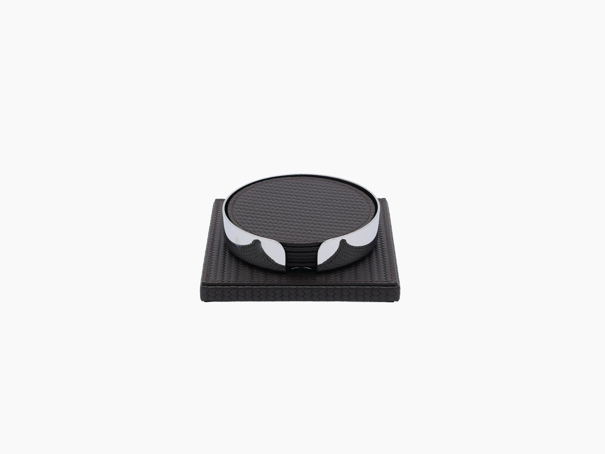 Clear cut glass tumbler resting on a dark leather coaster atop a leather wrapped square base.