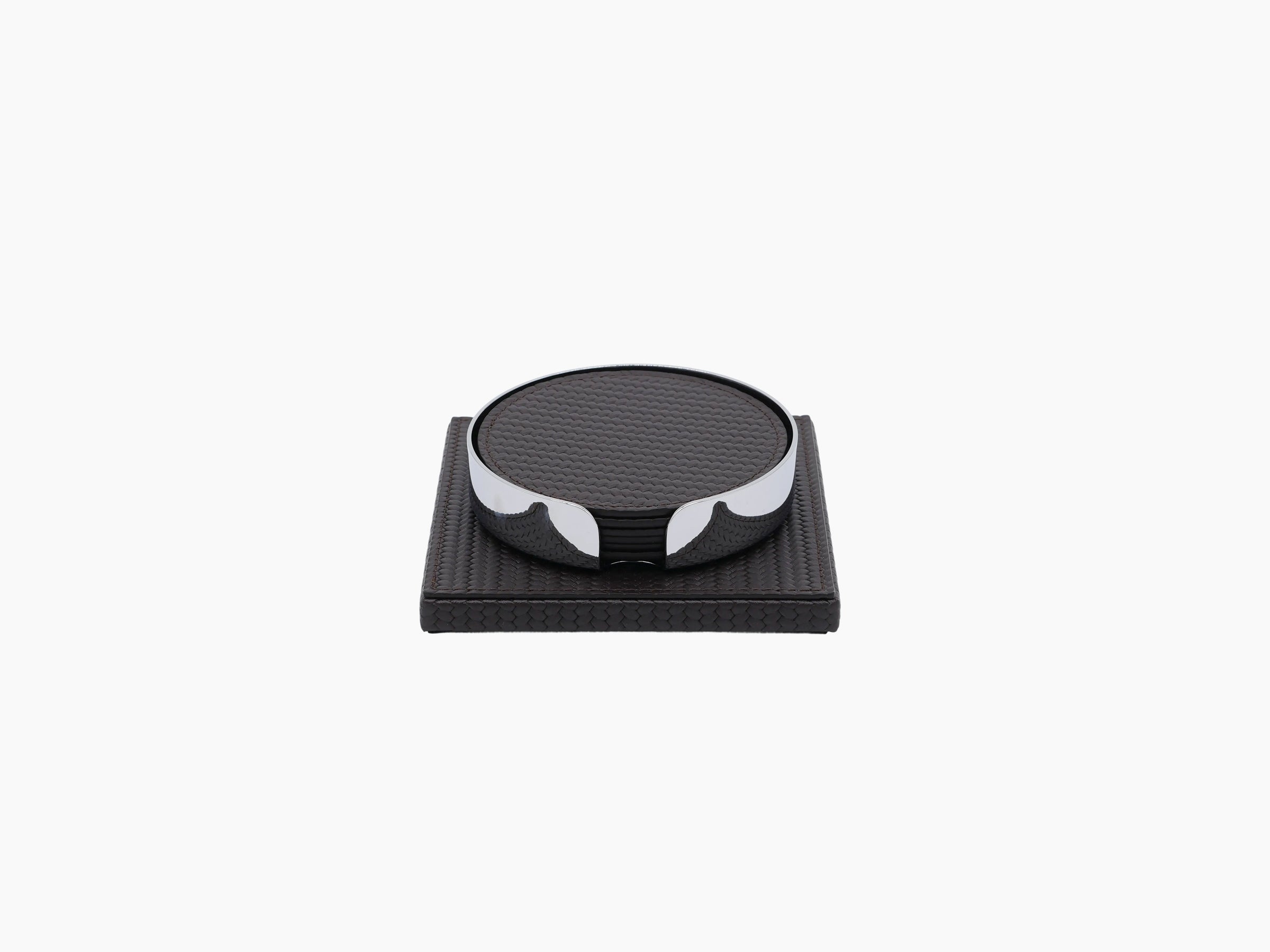 Clear cut glass tumbler resting on a dark leather coaster atop a leather wrapped square base.