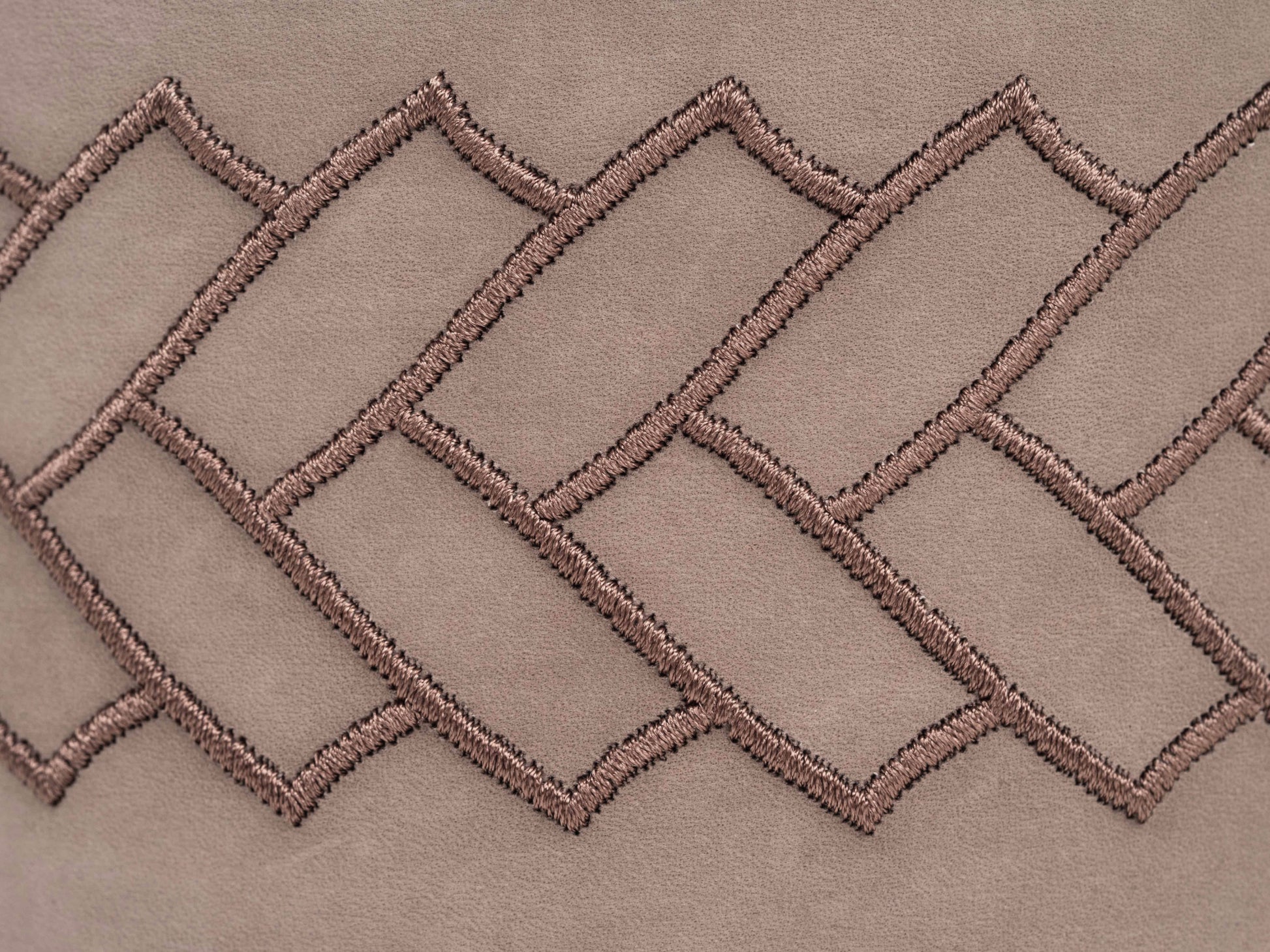 Close-up of taupe leather with interwoven herringbone stitch pattern