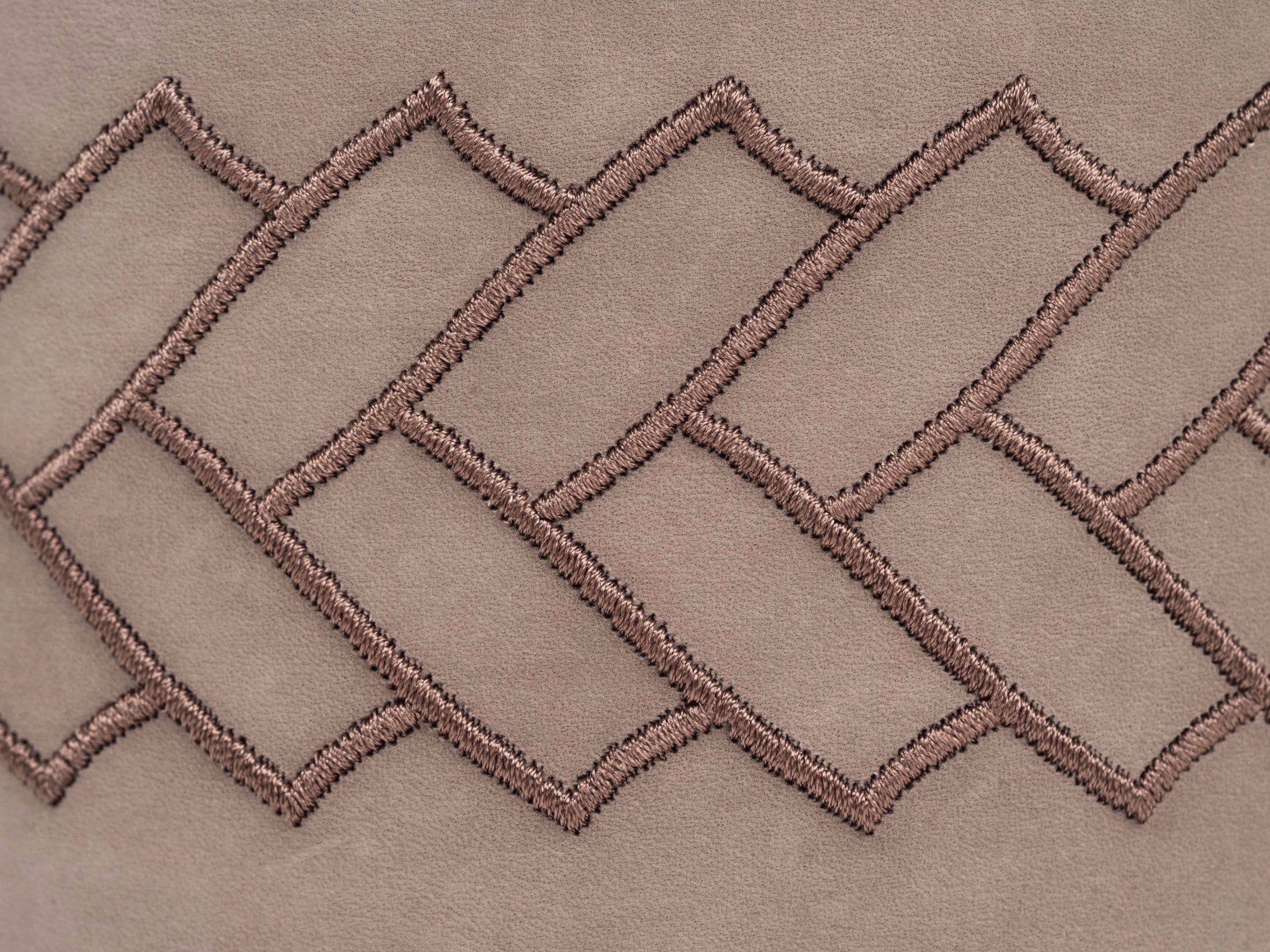 Close-up of taupe leather with interwoven herringbone stitch pattern