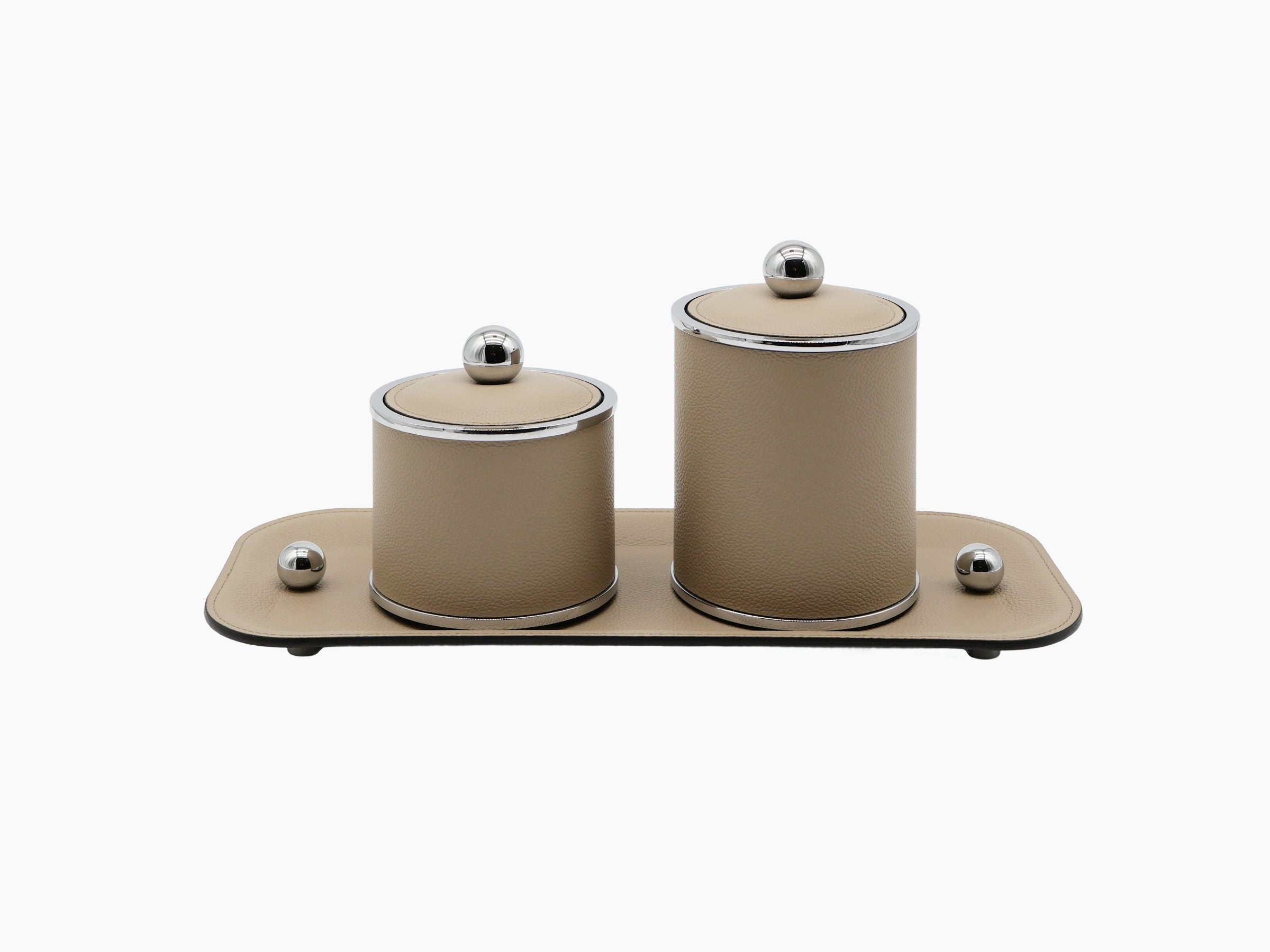 Two Olimpia round leather bathroom boxes on a beige leather tray with chrome rims and knob lids.