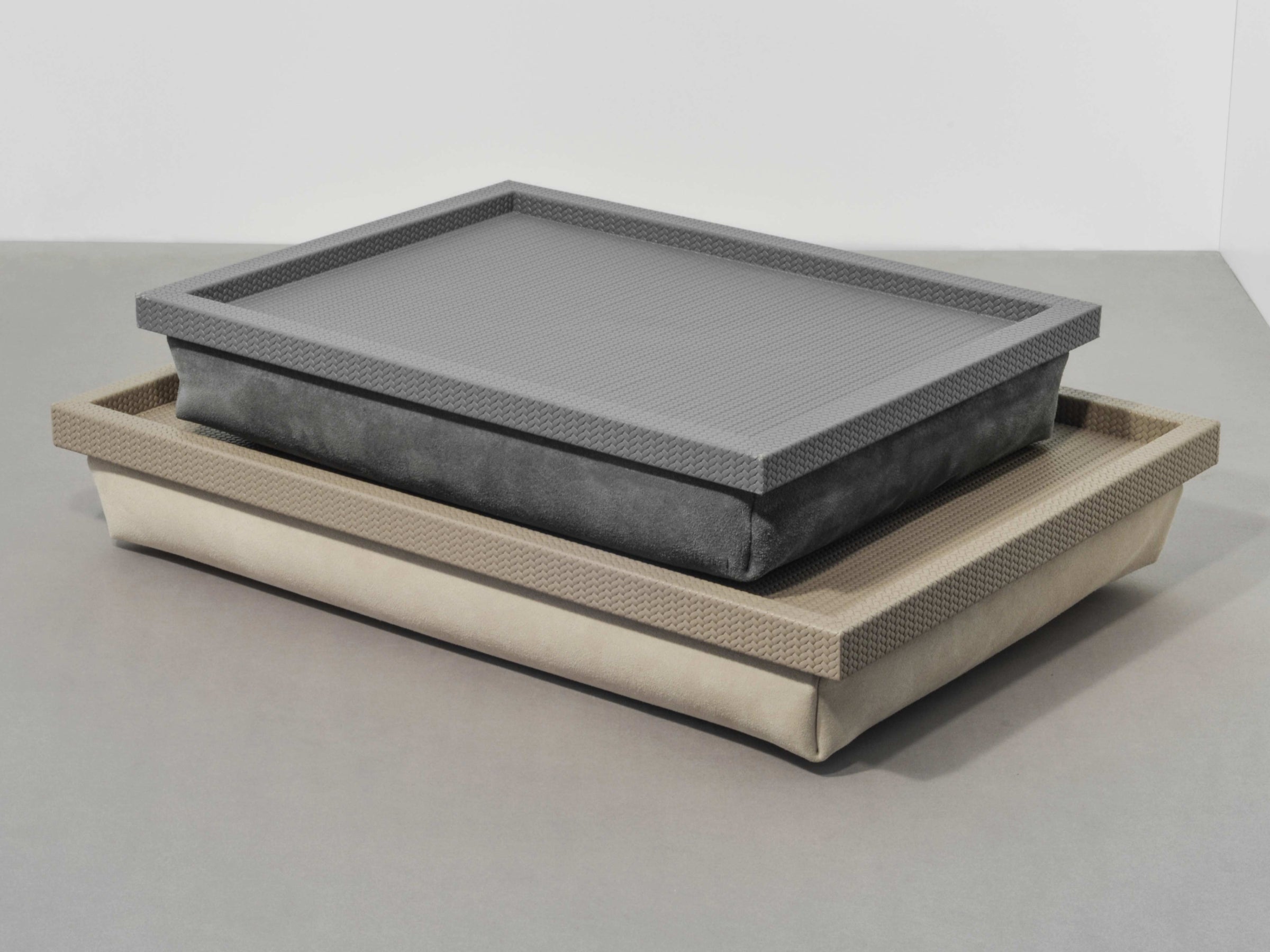 Stacked Teseo Bed Trays in beige and gray with textured frames and suede bases