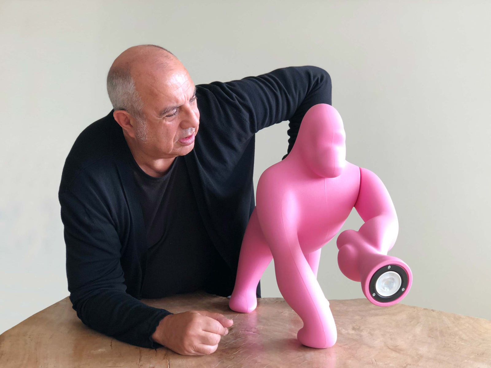 Pink Kong Lamp XS sculpture in use with a person beside it, highlighting the playful gorilla form and light feature.