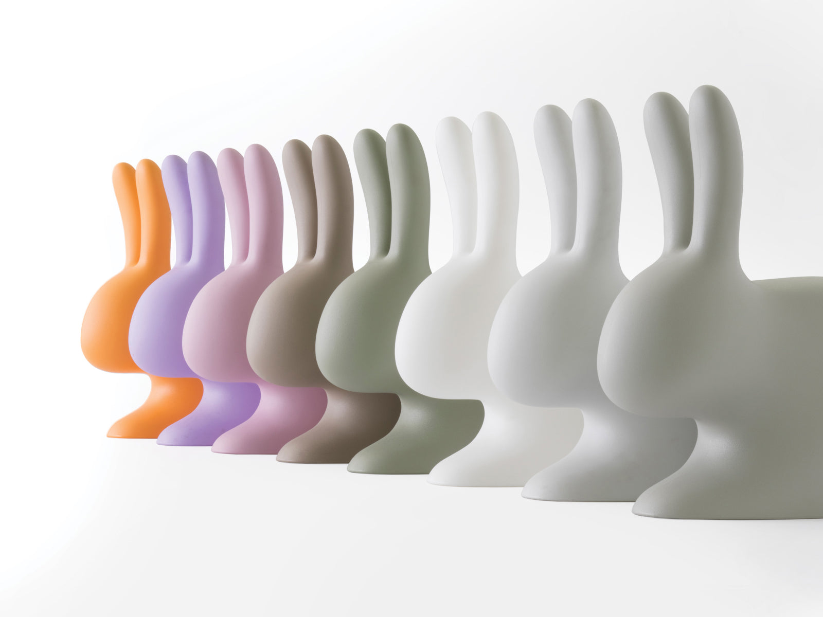 Row of Baby Rabbit Chairs in pastel colors lined up along a white background