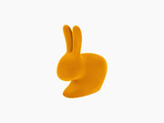 Velvet dark gold Rabbit Chair sculpture isolated on a white background.
