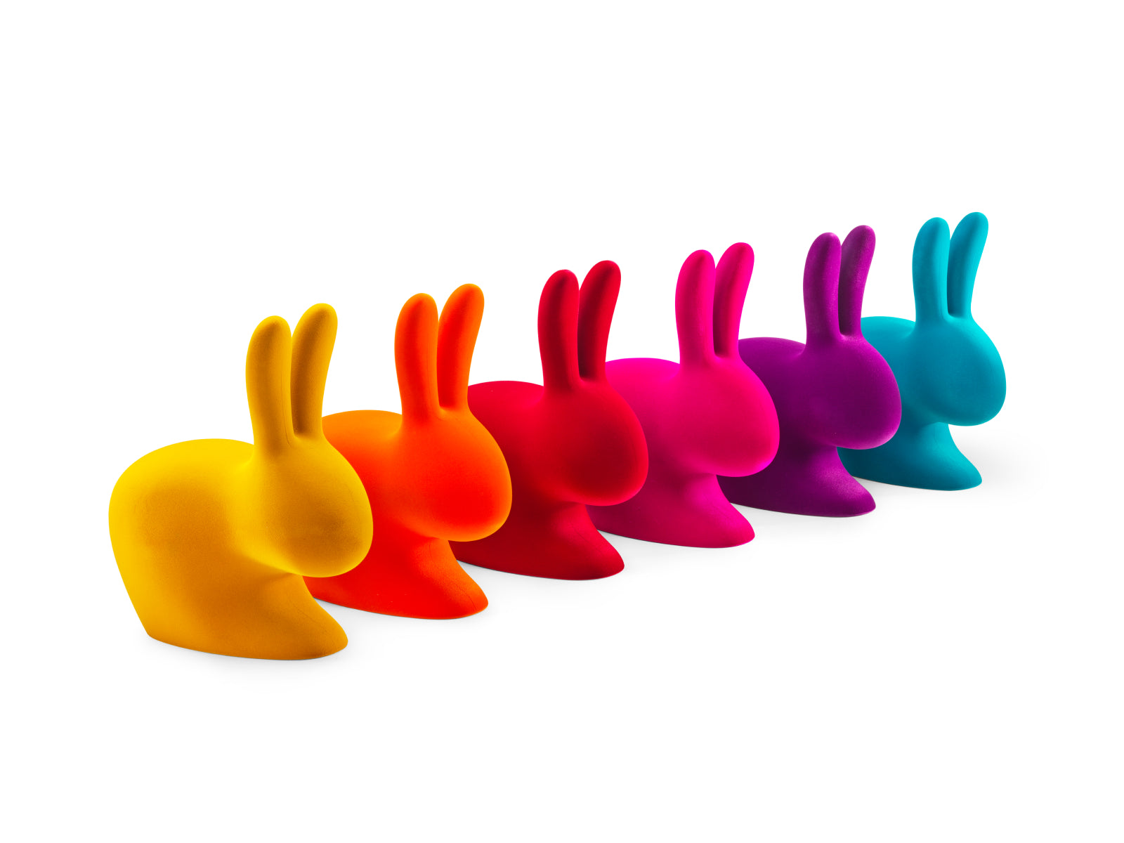 Row of colorful rabbit chairs in yellow orange red pink purple and blue on a white background