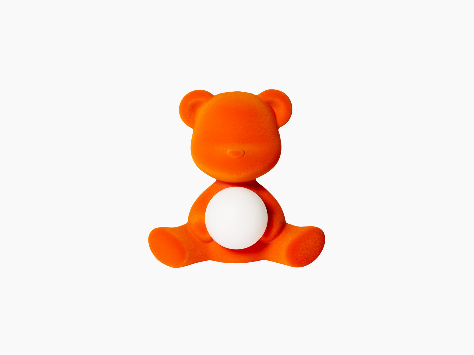 Teddy Girl Velvet Flock Orange LED lamp sits with a white sphere resting in its lap against a white background