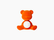 Teddy Girl Velvet Flock Orange LED lamp sits with a white sphere resting in its lap against a white background