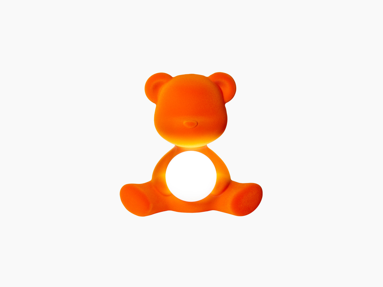 Orange Teddy Girl LED lamp in velvet finish sits with a glowing white sphere cradled in its arms.