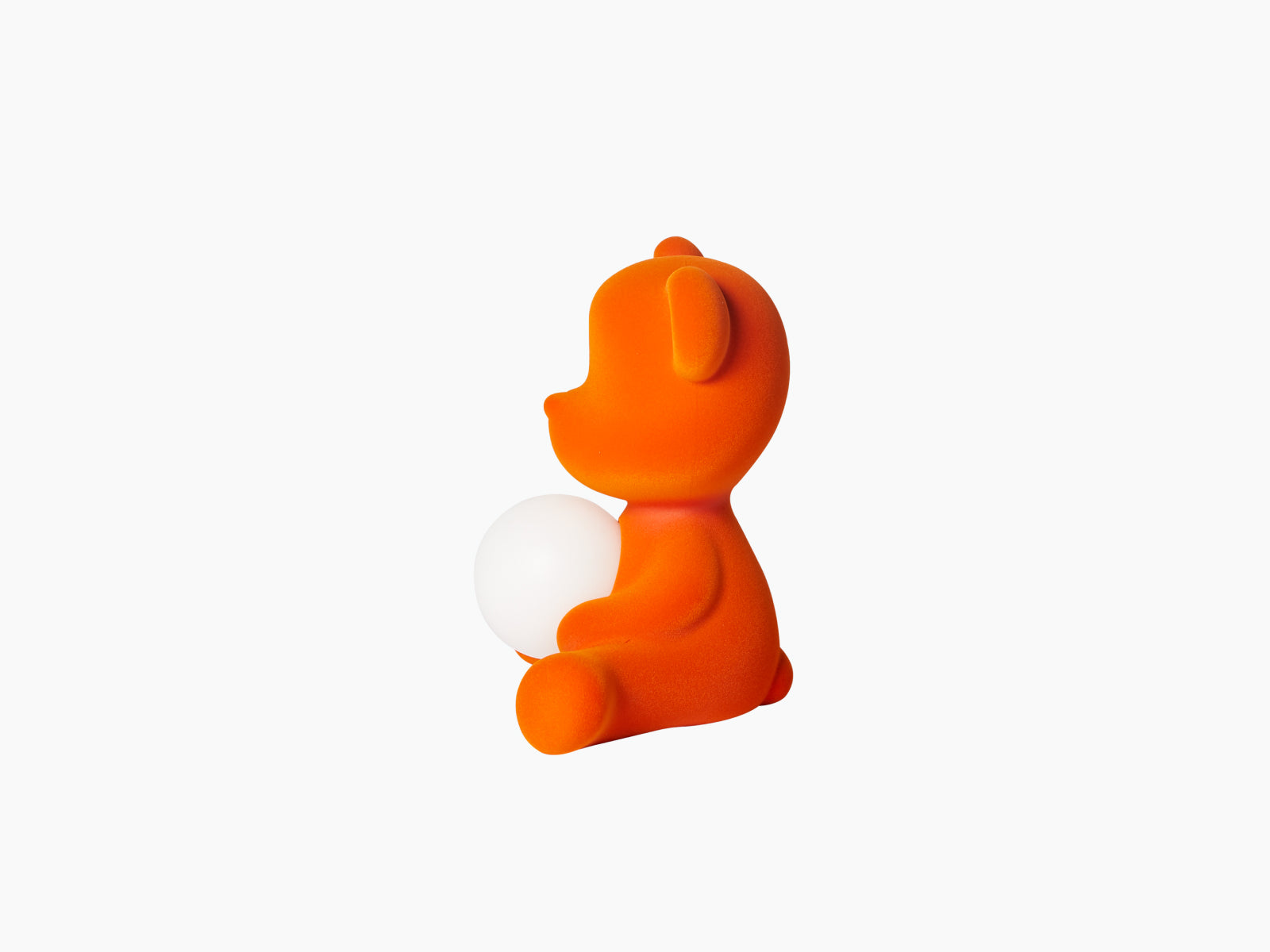 Orange velvet Teddy Girl lamp seated and cradling a white sphere