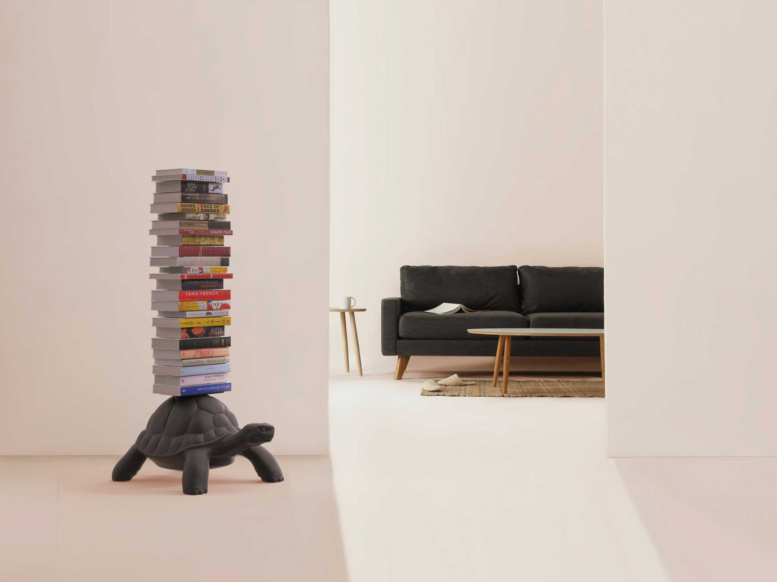 Tall stack of books balanced on a Turtle Carry Bookcase base in a bright minimalist room