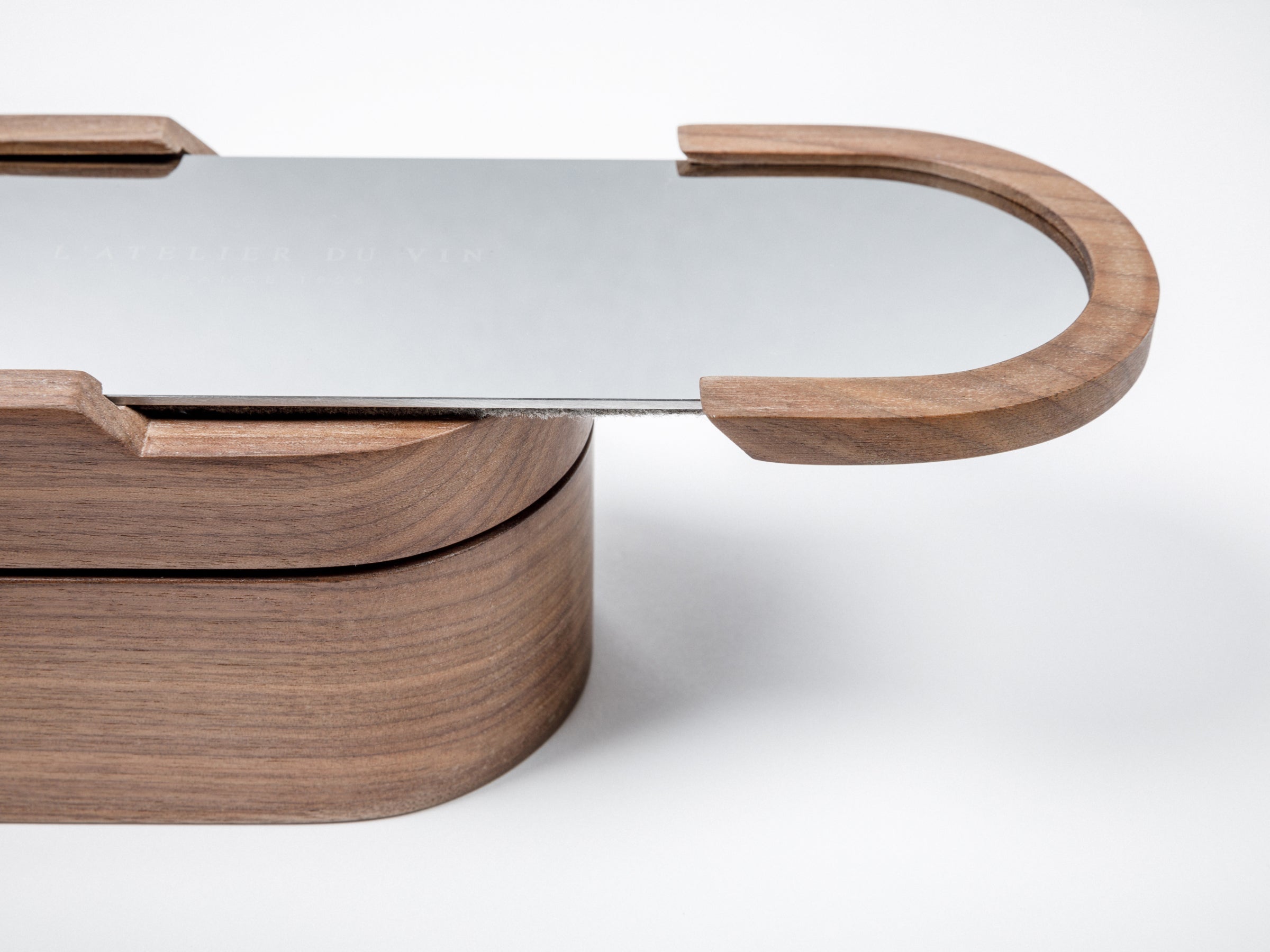 Side view of the walnut Sparkling Set with curved wooden handle and a sliding metal lid.