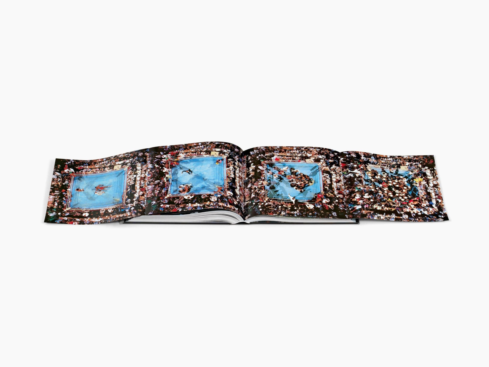 Open book featuring large panoramic pages of boxing ring scenes and crowds from the Muhammad Ali tribute volume.