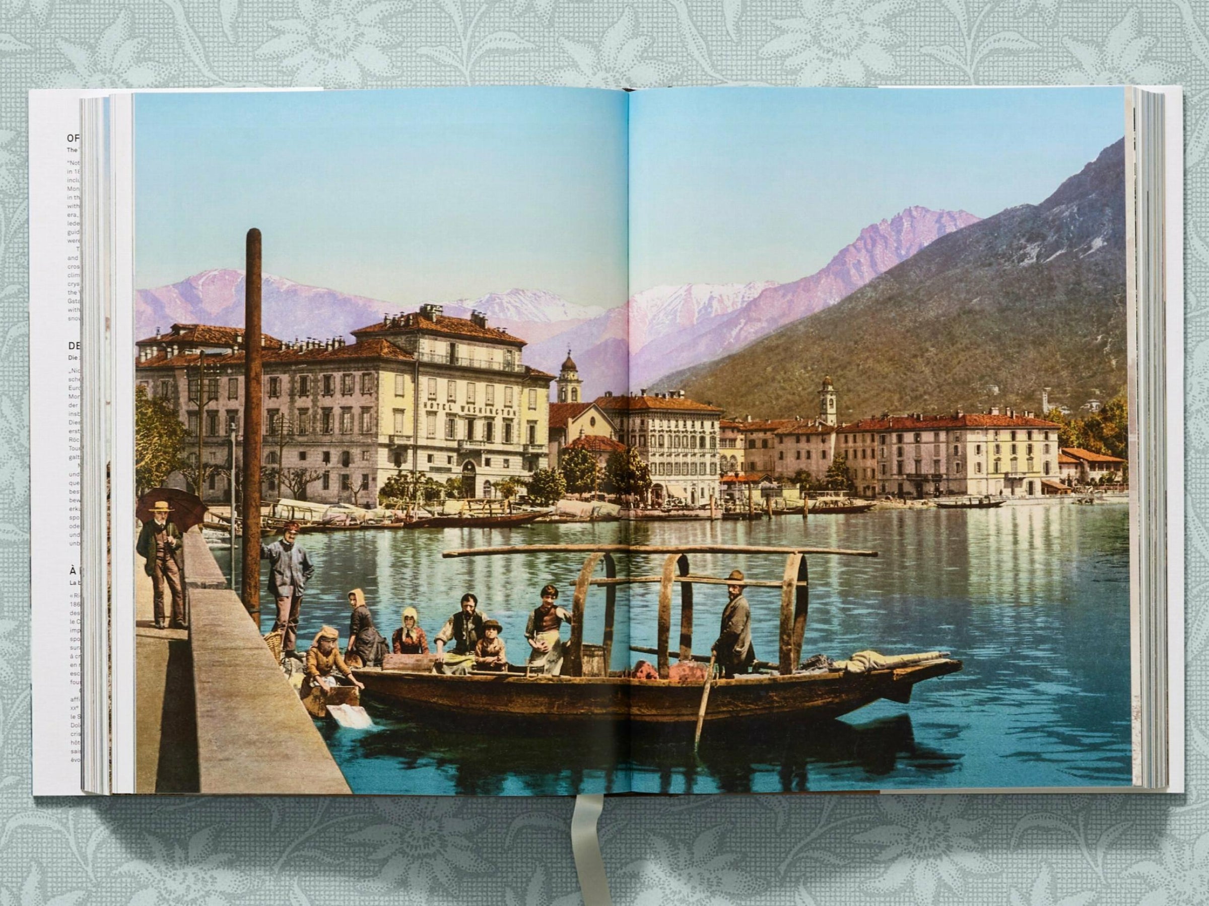 Lakeside alpine town with a boat on calm water and snow capped mountains in the distance from The Alps 1900 A Portrait in Color
