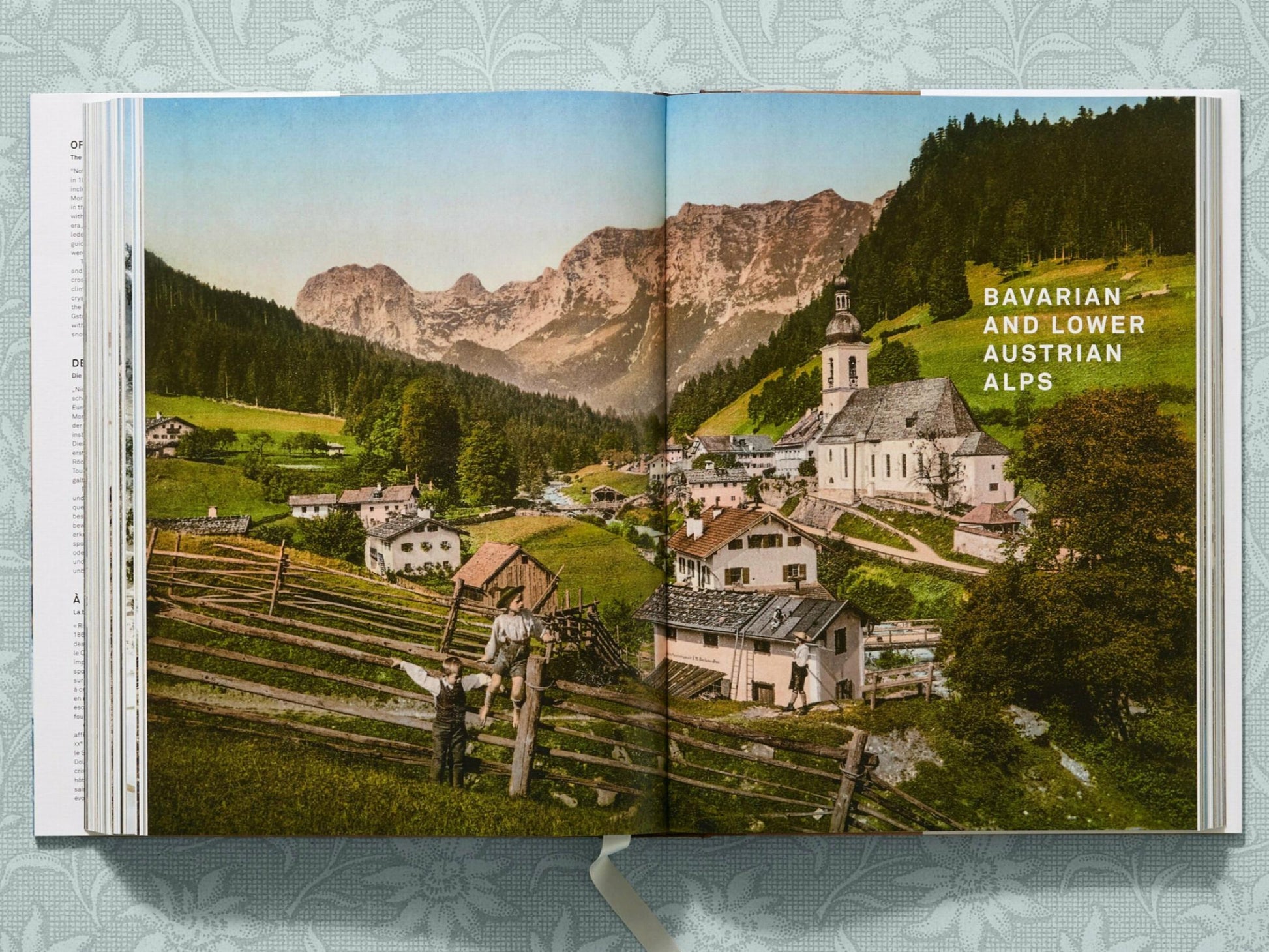 Colorized alpine village with a church, houses, a fence, and snow-capped peaks in the Bavarian and Lower Austrian Alps.
