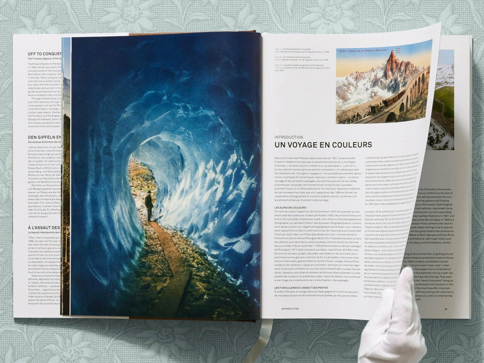 Open book spread showing a blue glacier scene on the left and a white page on the right with a small mountain photo and UN VOYAGE EN COULEURS text