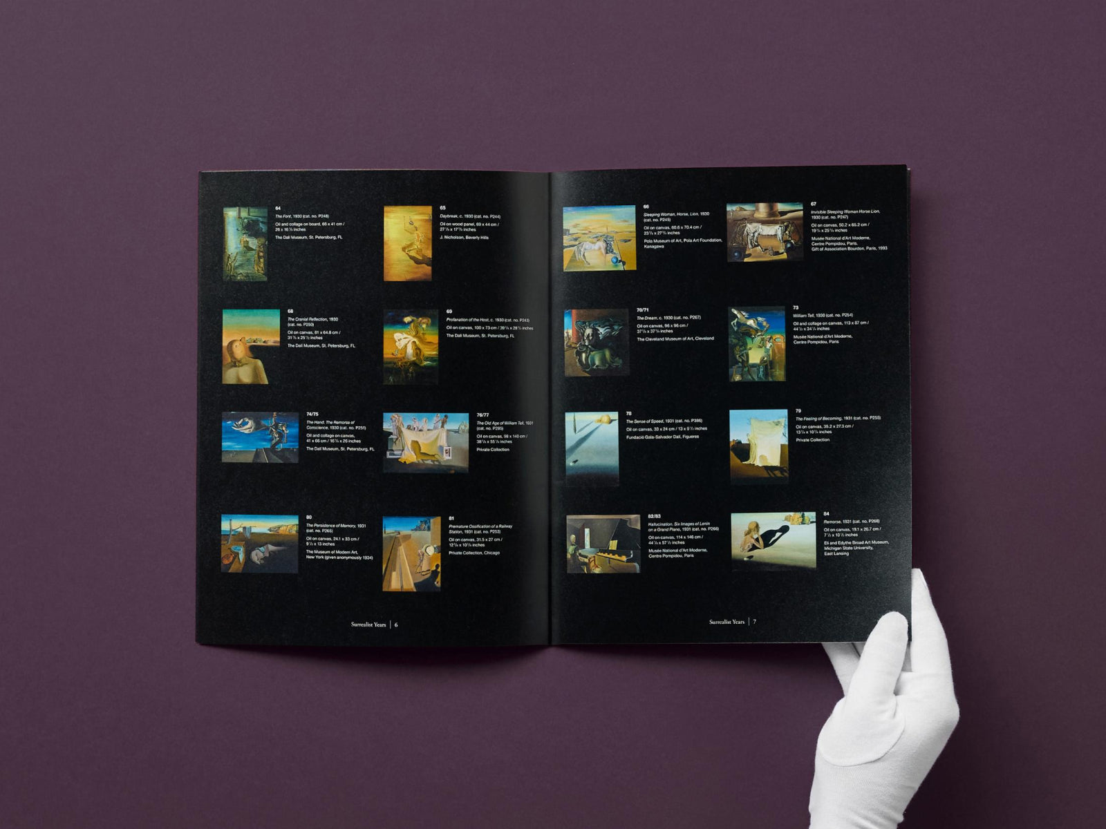 Open Dalí catalog spread with thumbnail artworks on dark pages held by a white gloved hand.