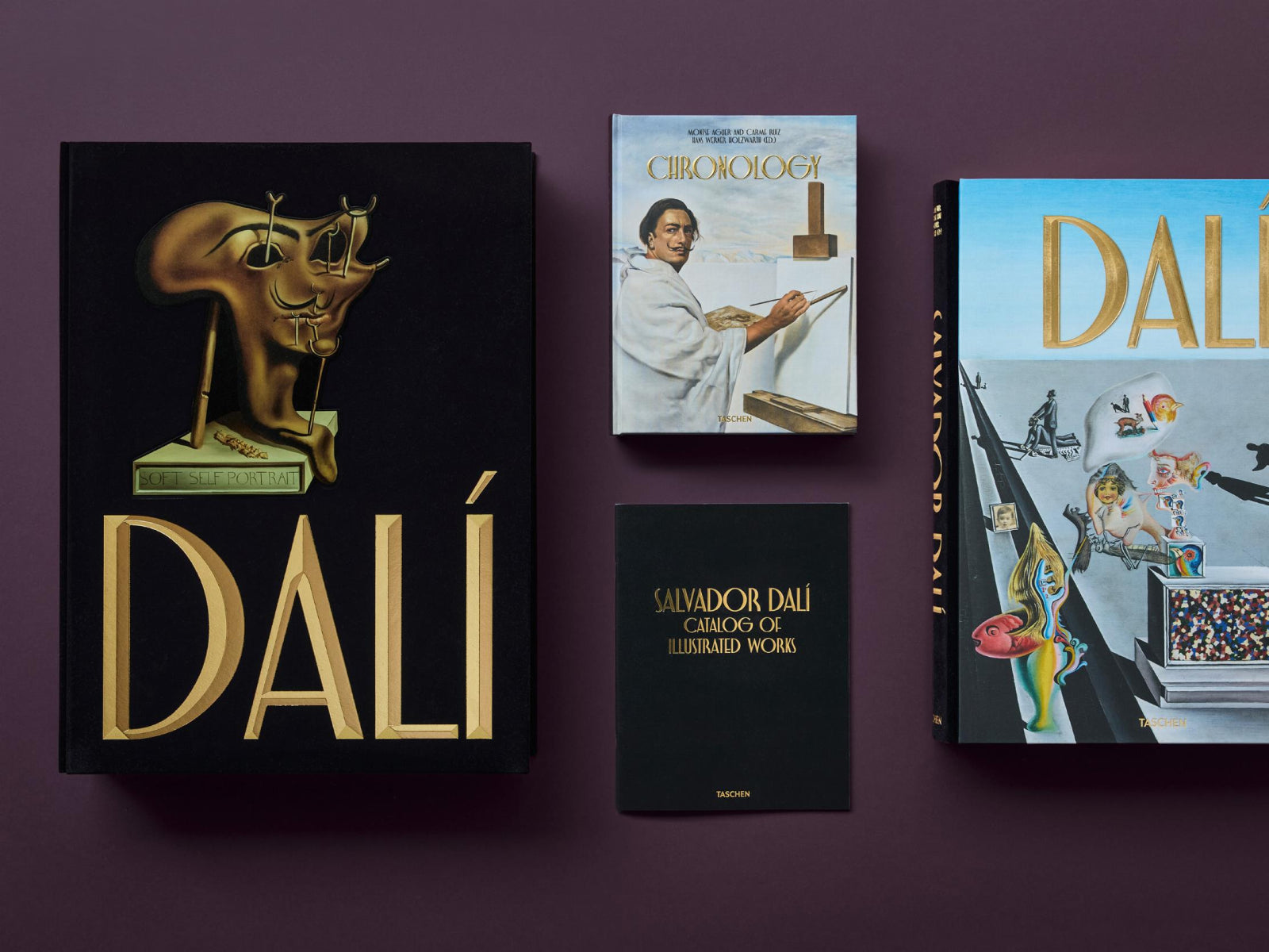 DALI The Complete Paintings set arranged on a purple surface with a large black book, a blue chronology volume, and a black catalog.