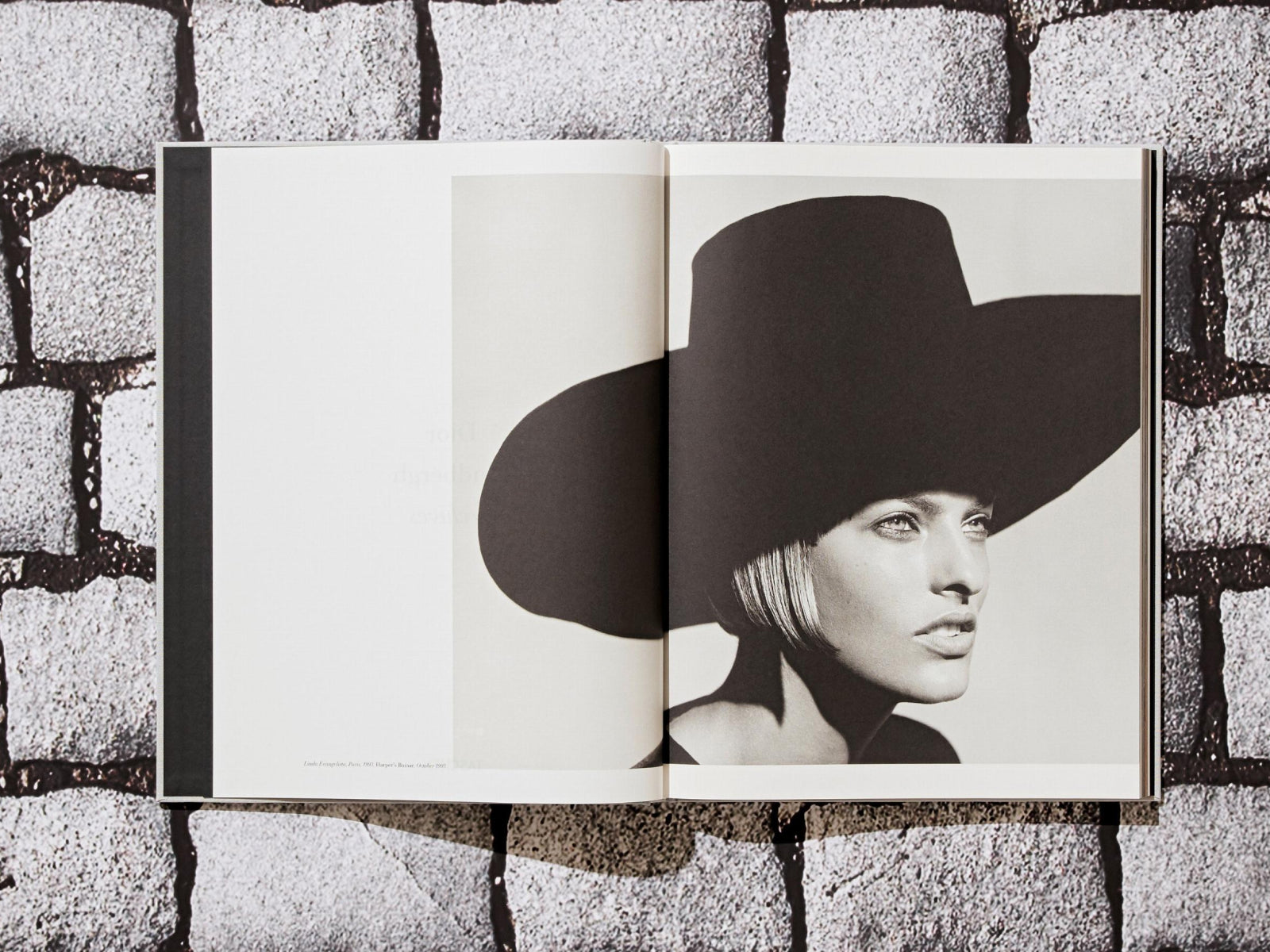 Open book showing a black and white portrait of a model wearing a large wide brim hat.