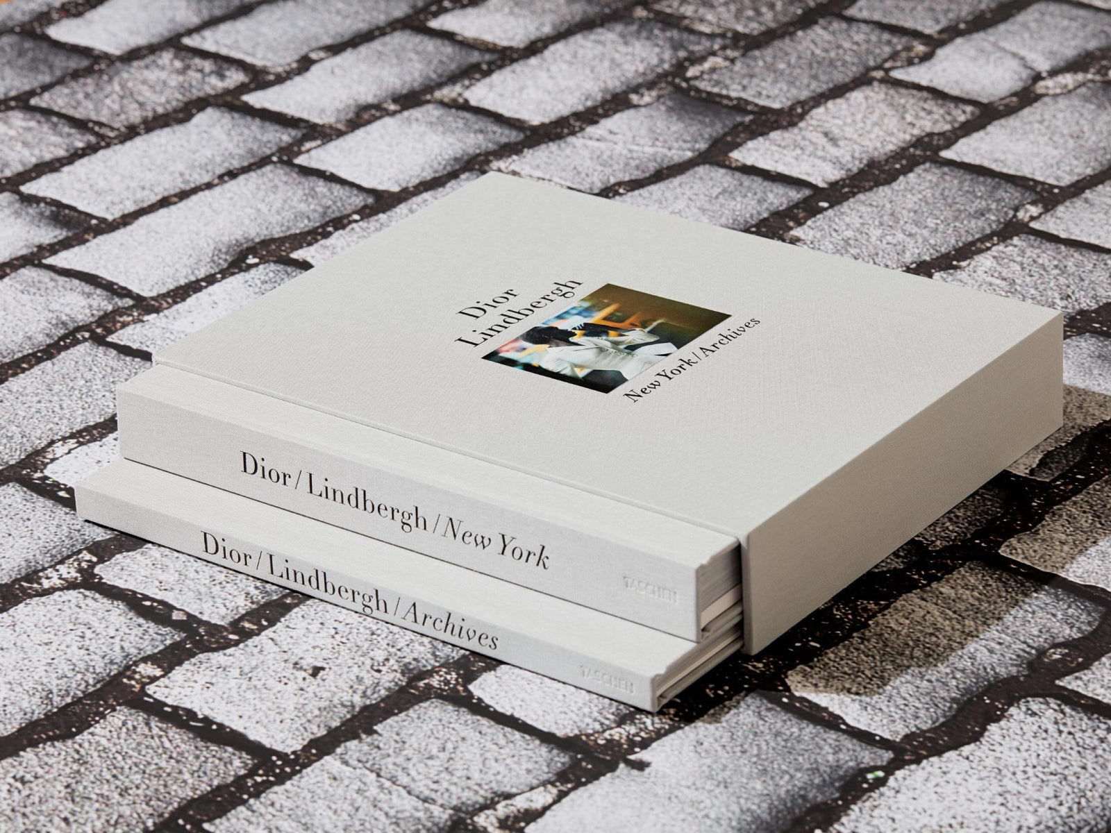 Boxed two-volume Dior Lindbergh New York Archives set with white spines, shown on a cobblestone surface