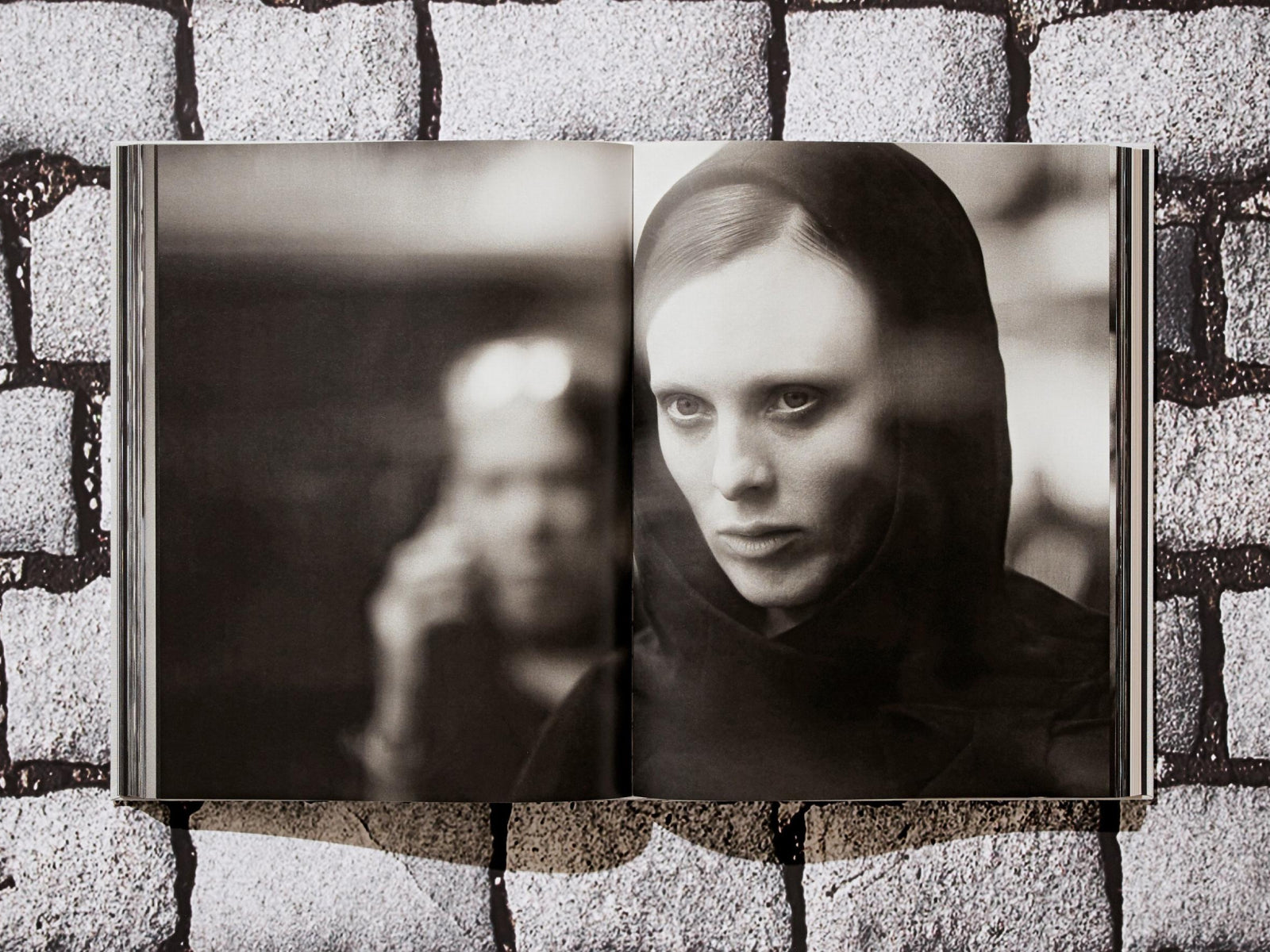 Open two page spread in a black and white Peter Lindbergh Dior photography book showing a hooded portrait.