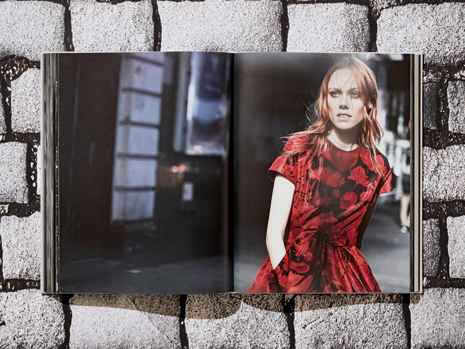 Color photograph from Peter Lindbergh Dior showing a model in a red floral dress on a city street with a serious expression.