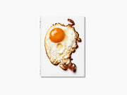 The Gourmand’s Egg book cover featuring a sunny side up egg on a white background with an orange backdrop