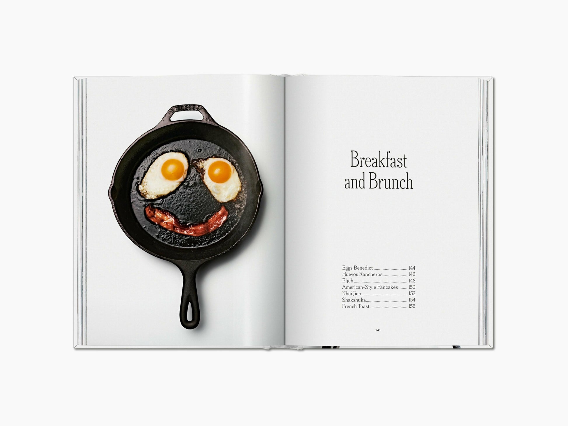 Face formed by two fried eggs and bacon in a cast iron skillet