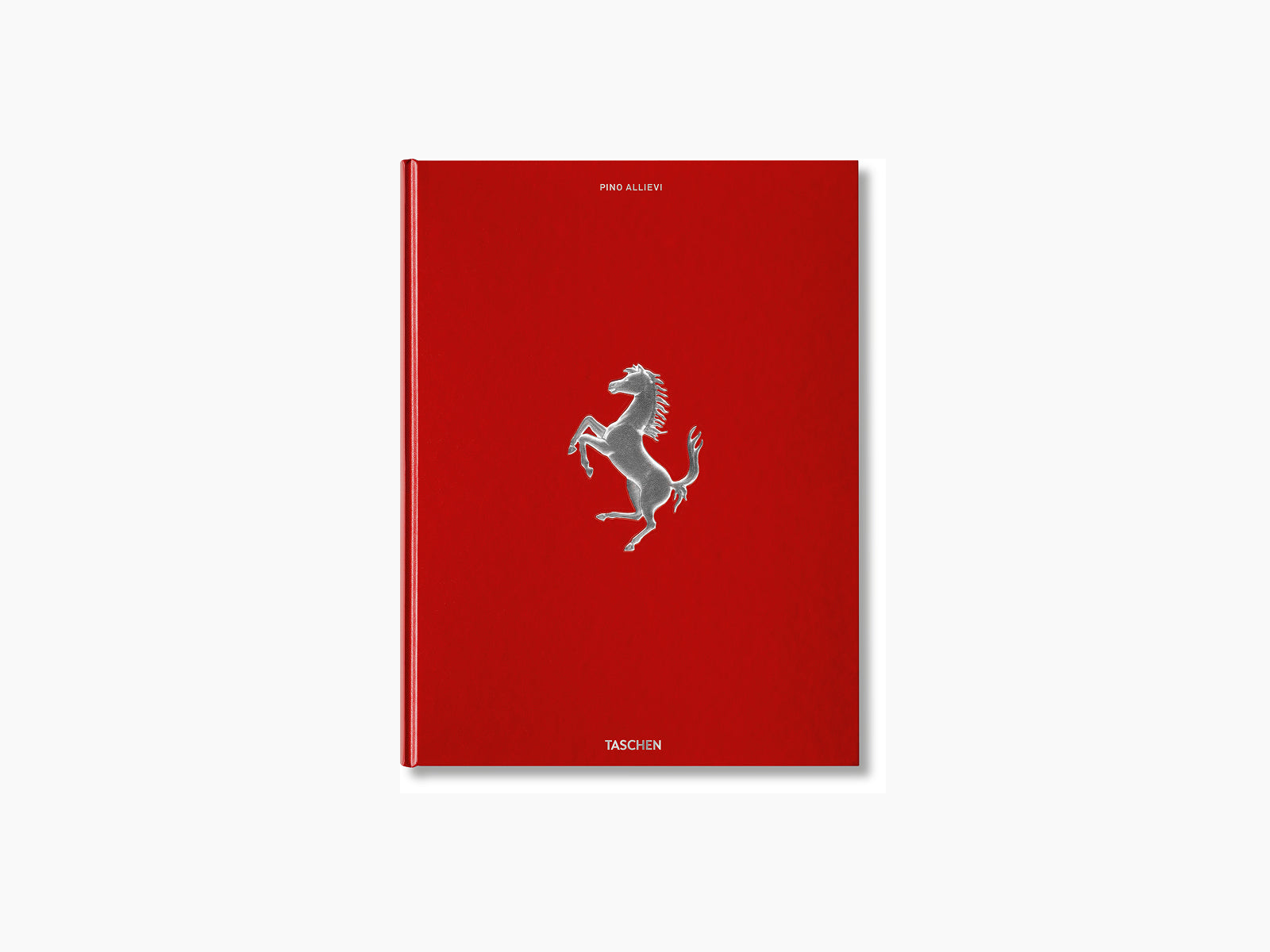 Red hardcover Ferrari book standing upright with a silver prancing horse emblem on the cover.