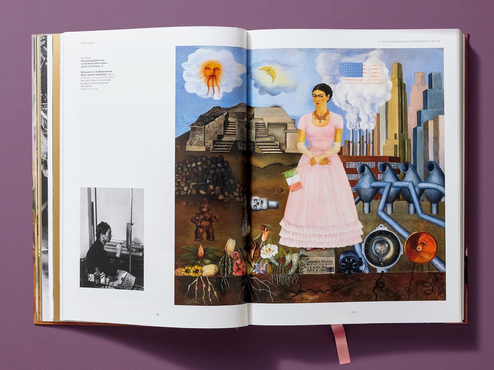 Two page spread from Frida Kahlo The Complete Paintings featuring a large color image of a woman in a pink dress in front of a cityscape with smokestacks and machinery.