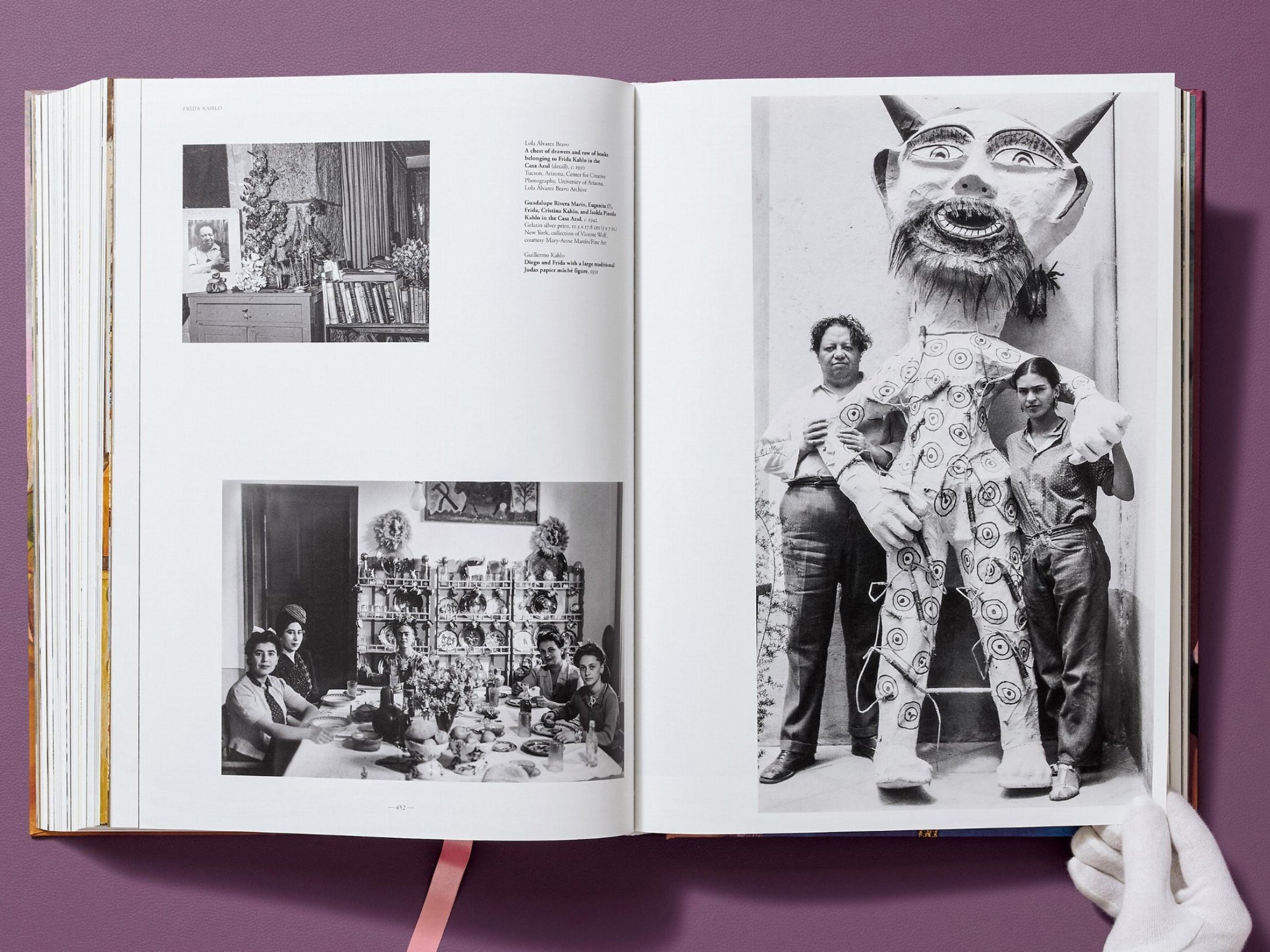 Spread from Frida Kahlo The Complete Paintings with a bright yellow left page and a grayscale painting of a factory skyline with smokestacks on the right