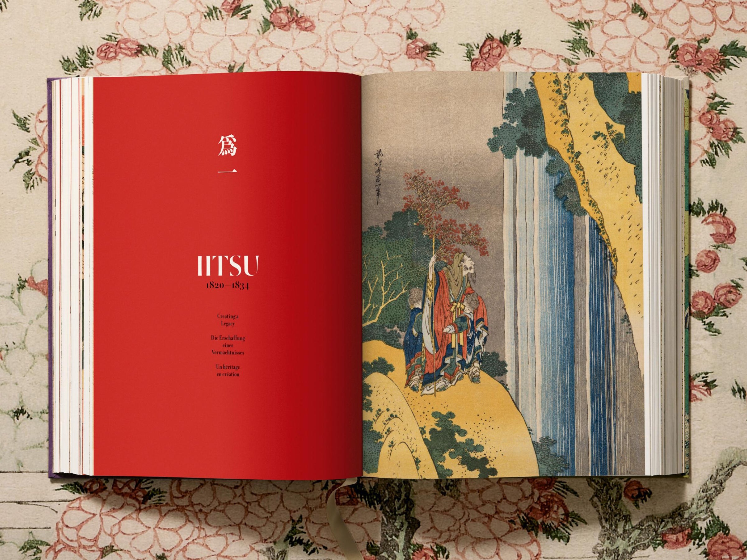 Open Hokusai volume with a bright red left page and a traditional print on the right.