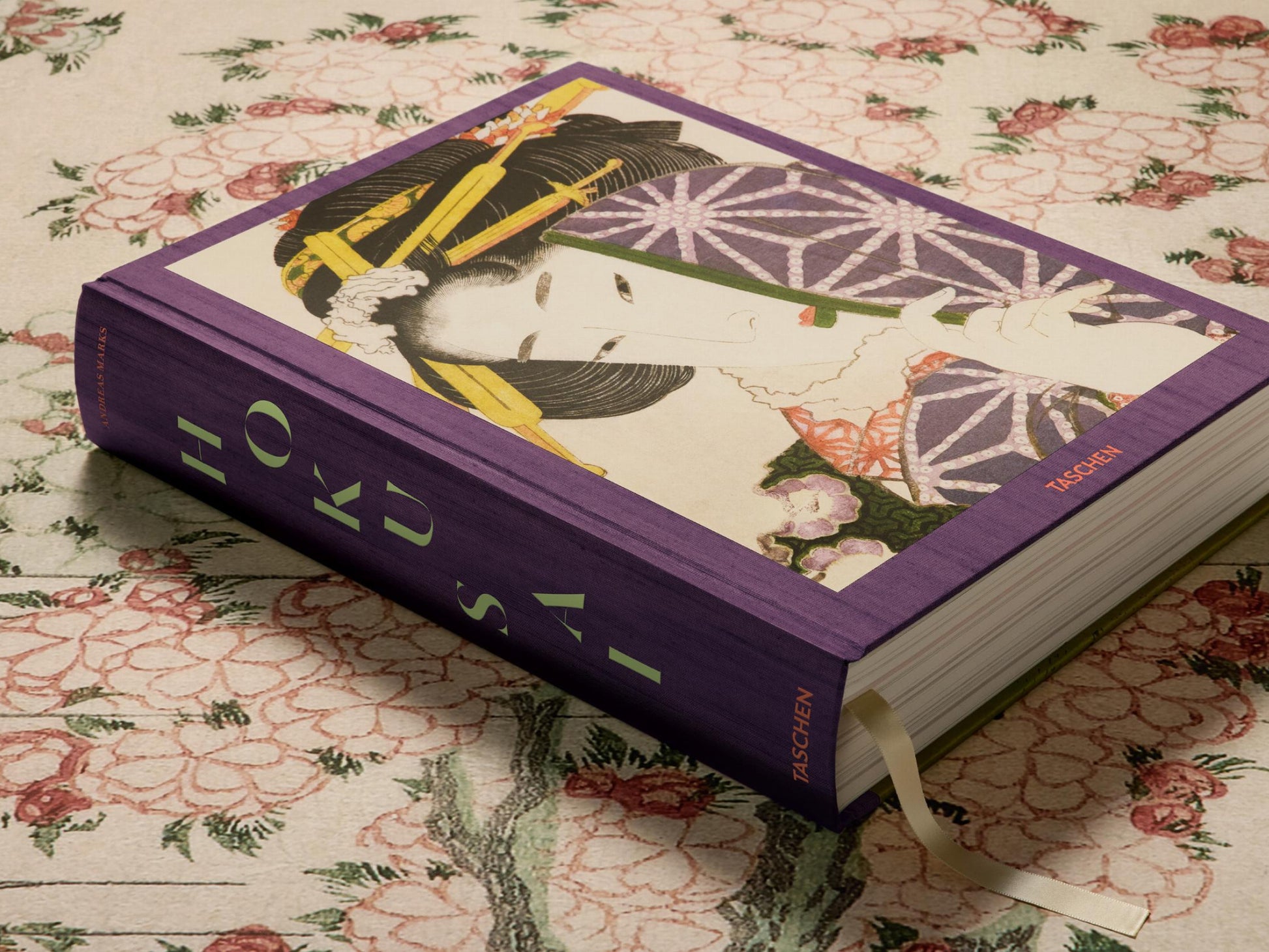 Purple Taschen Hokusai edition resting on floral fabric with a geisha portrait on the cover