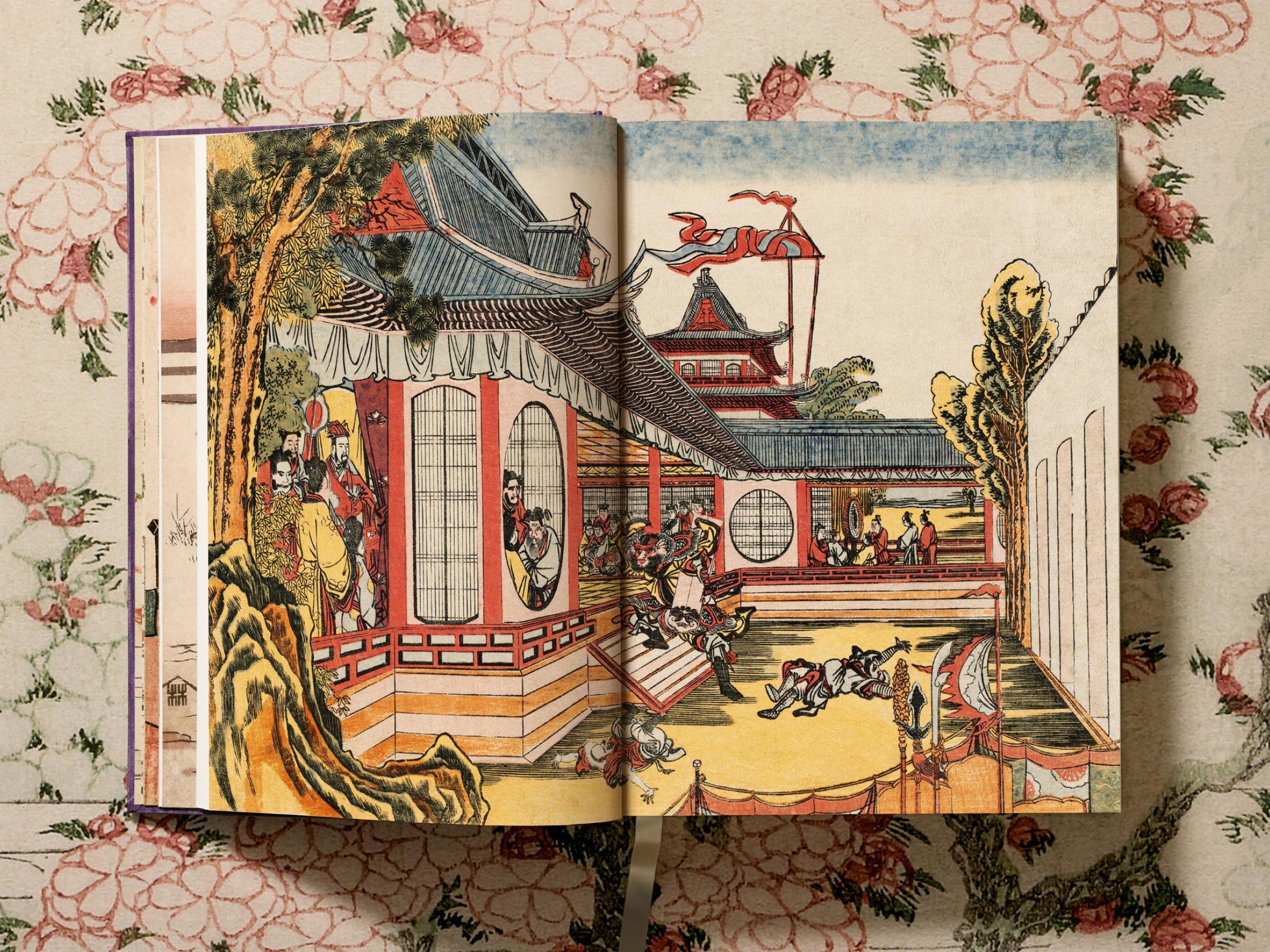 Open Hokusai art book showing a colorful Edo era print of a temple complex with figures on a terrace.