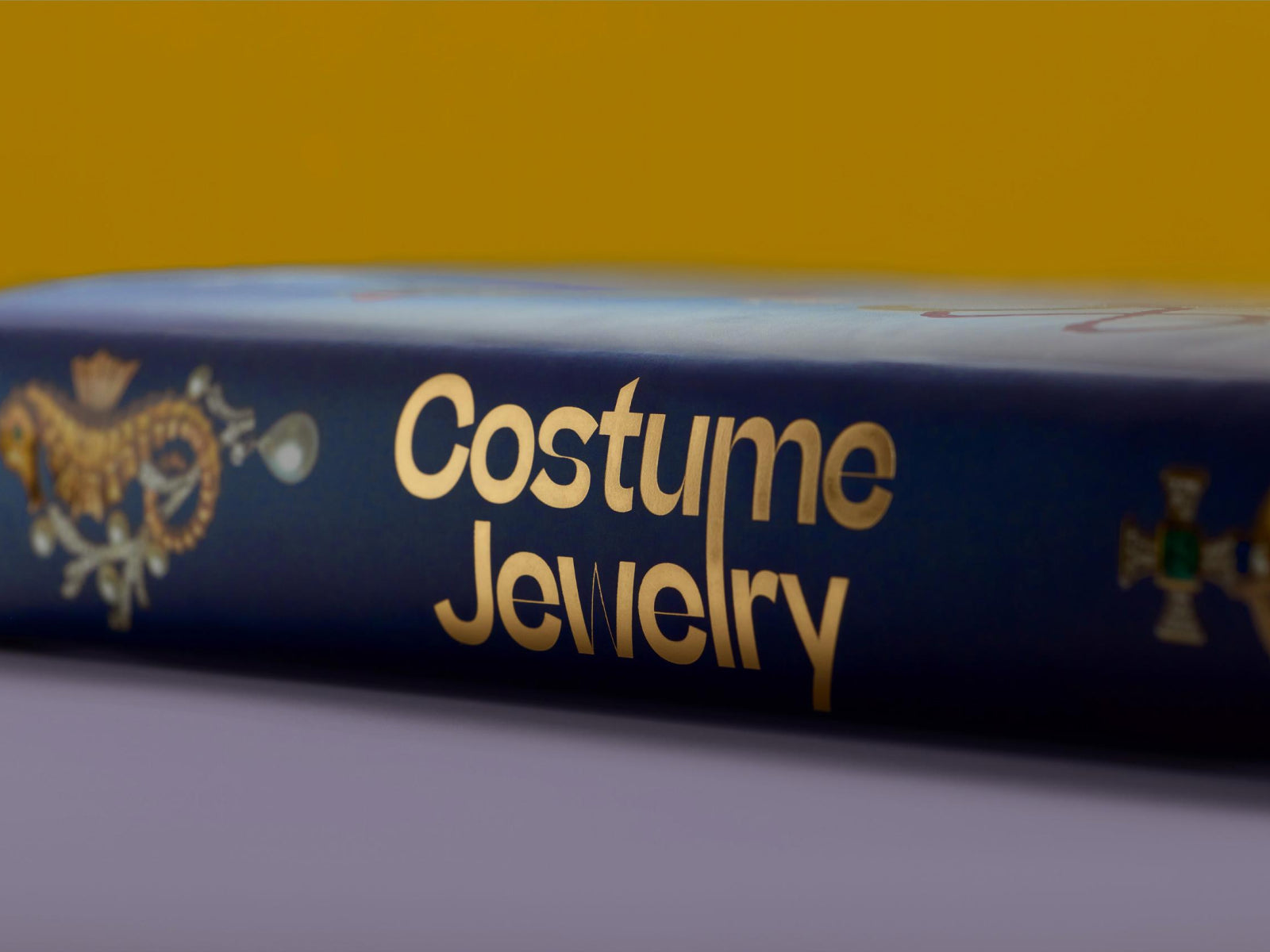 Close up of a blue book cover with gold Costume Jewelry title and decorative emblem