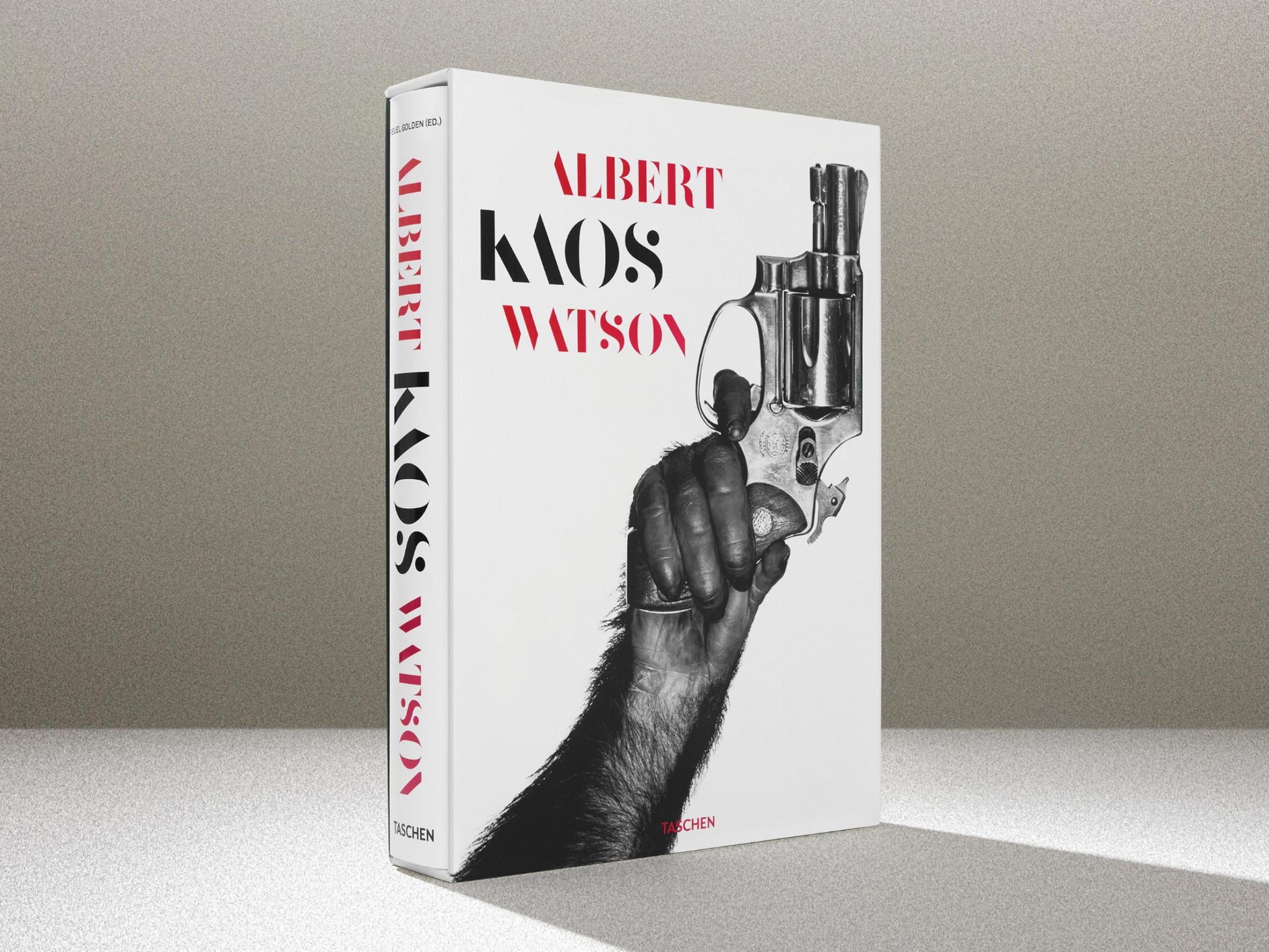 Kaos book cover by Albert Watson showing a large revolver illustration on white background with bold red and black typography.
