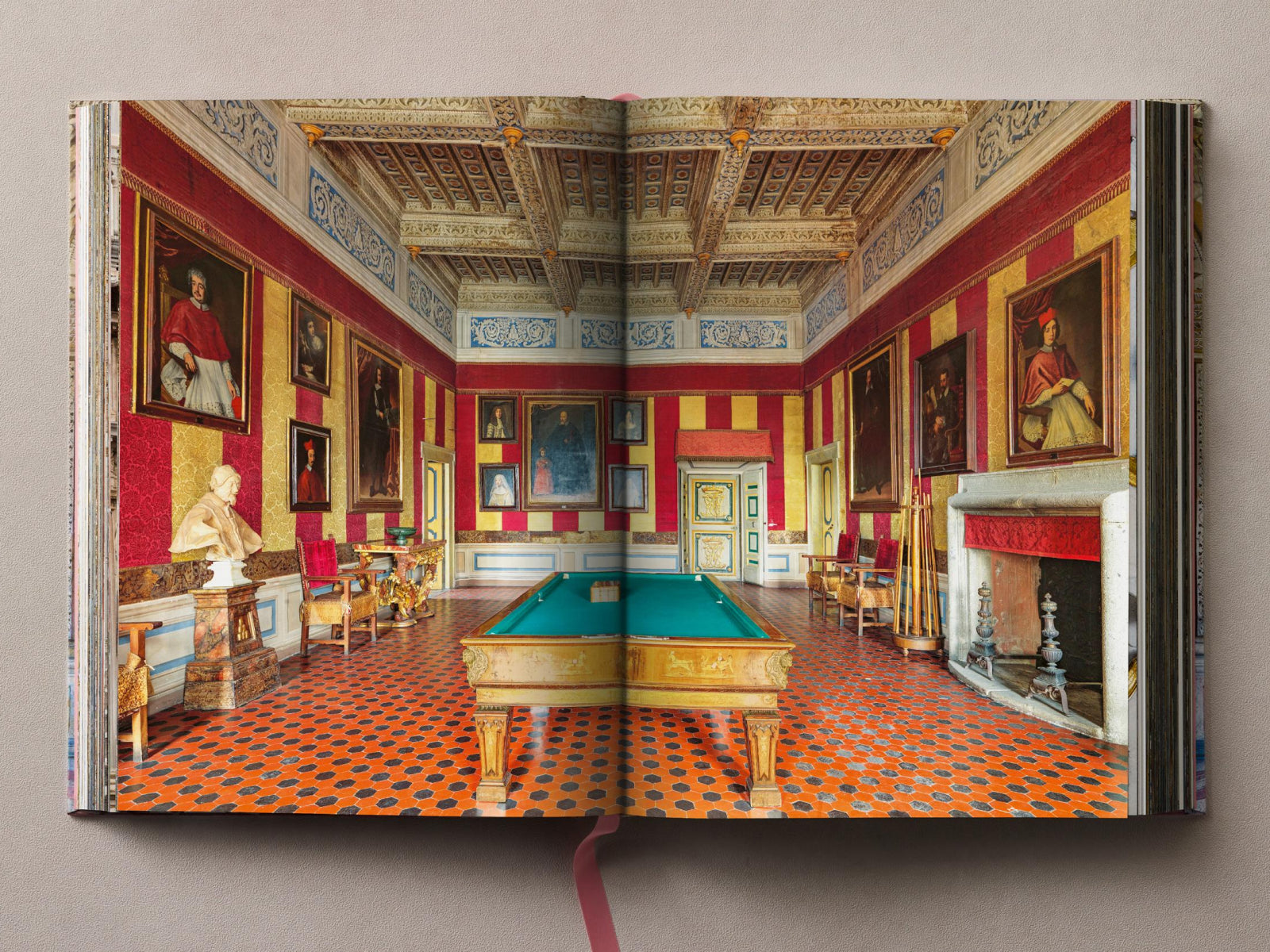 Opulent palace room with red and gold striped walls, large portraits, and a green billiard table under an ornate ceiling.