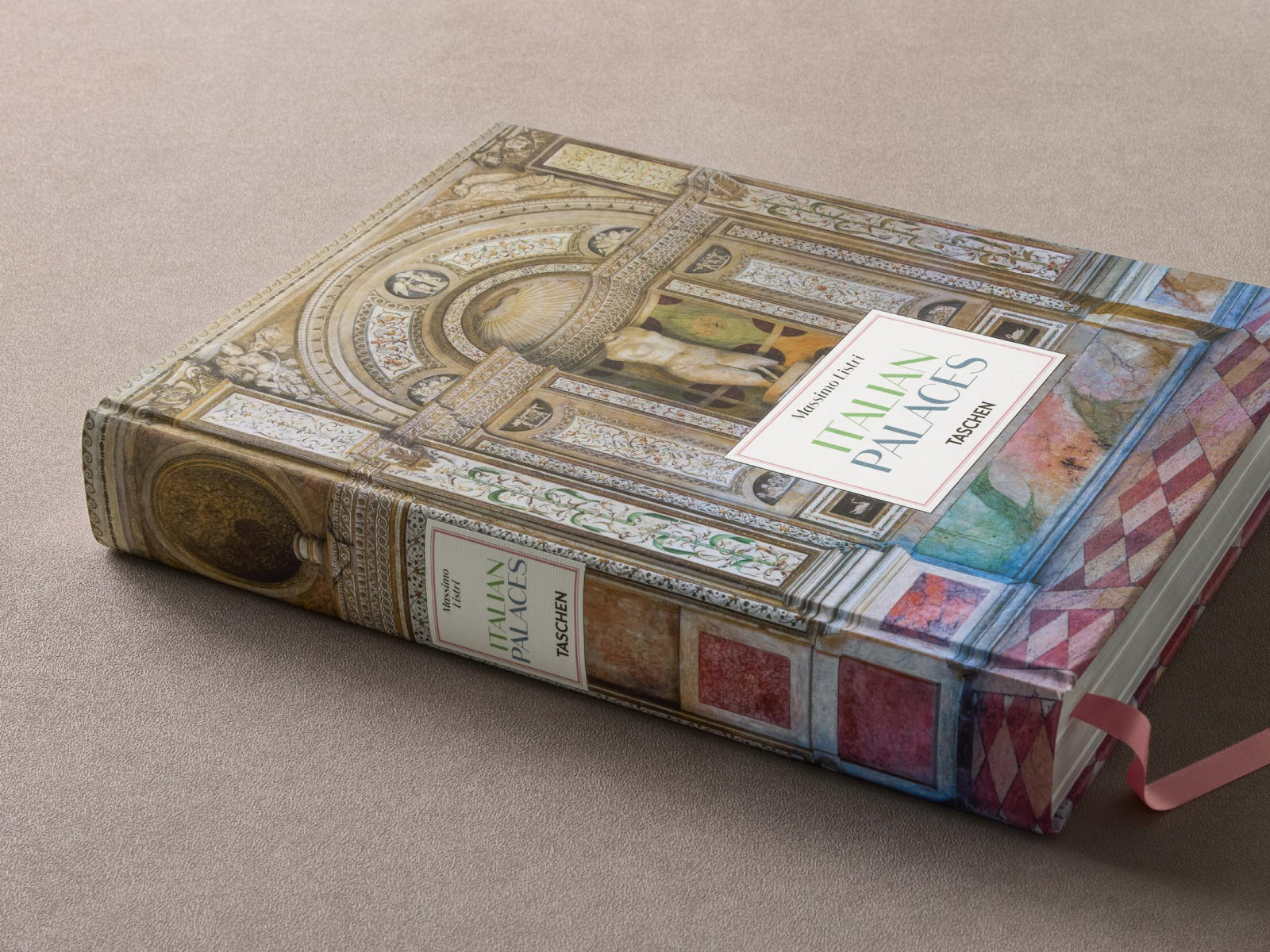 Hardcover Massimo Listri Italian Palaces resting on a beige surface with ornate cover and pink ribbon bookmark