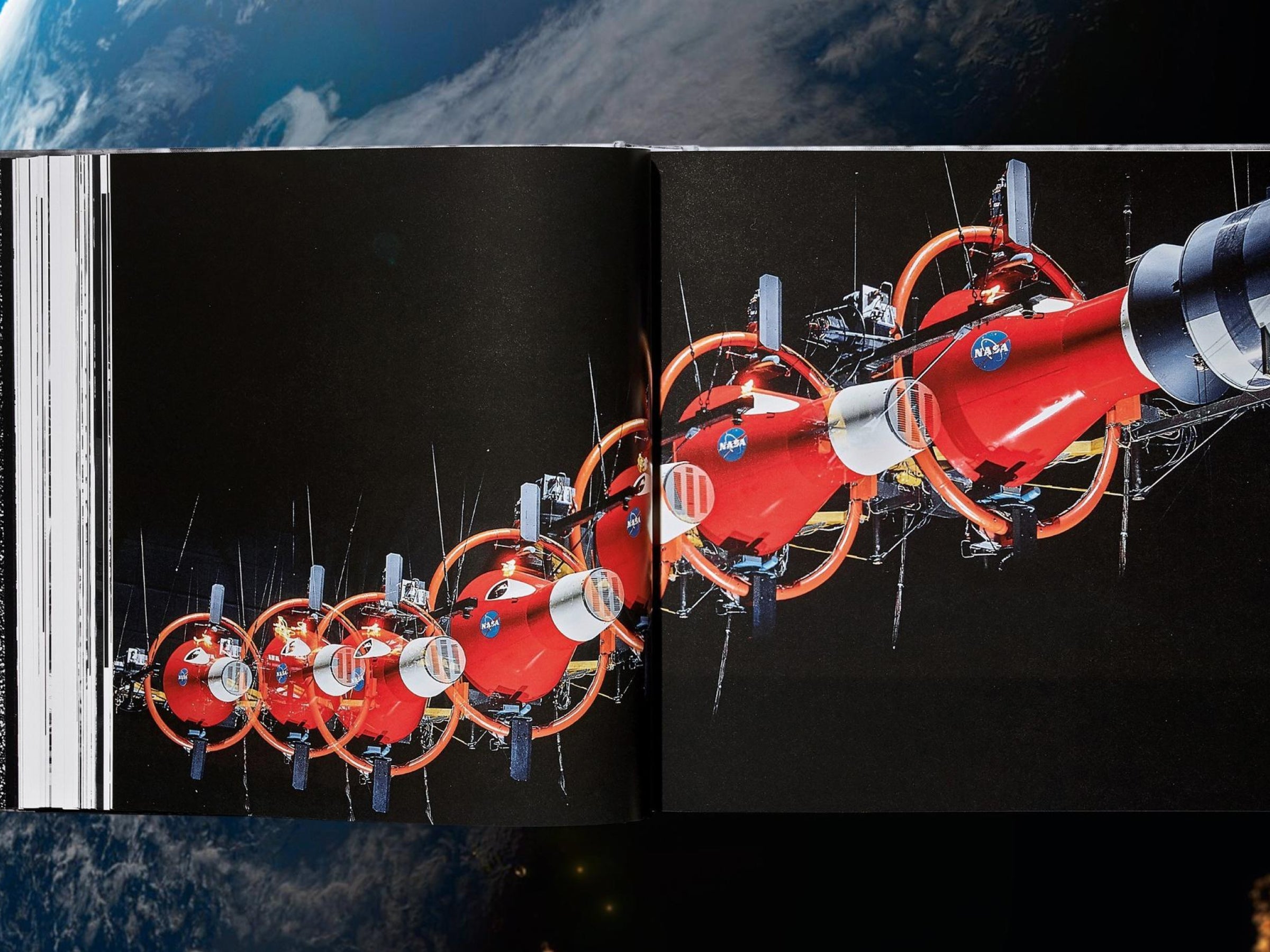 Two page spread from The NASA Archives featuring a red space apparatus with orange circular rings and NASA logos against black background.